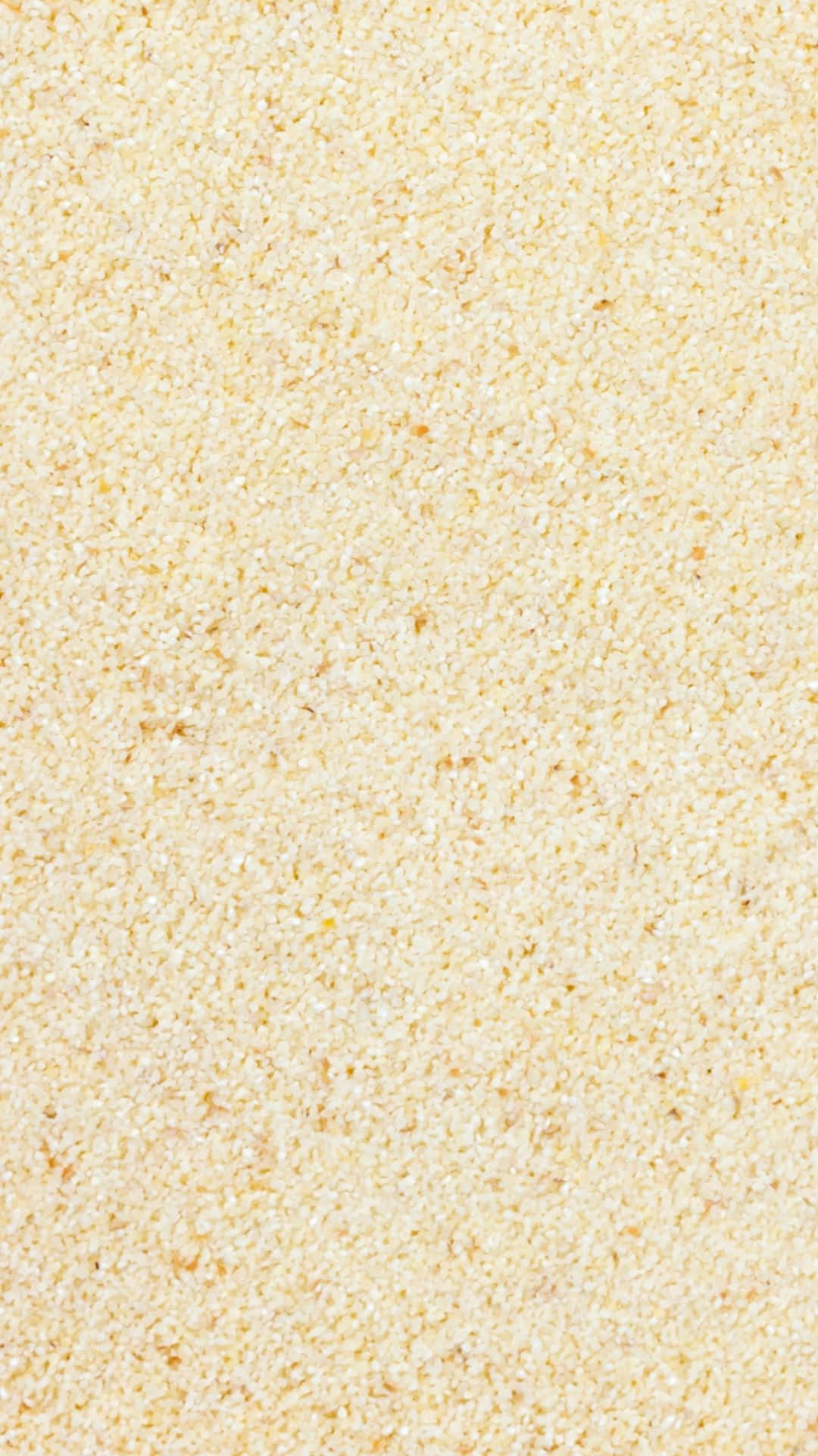 Textured 桌布 壁紙 — 細膩淡黃色顆粒質感的特寫，類似碎玉米粉或沙子。