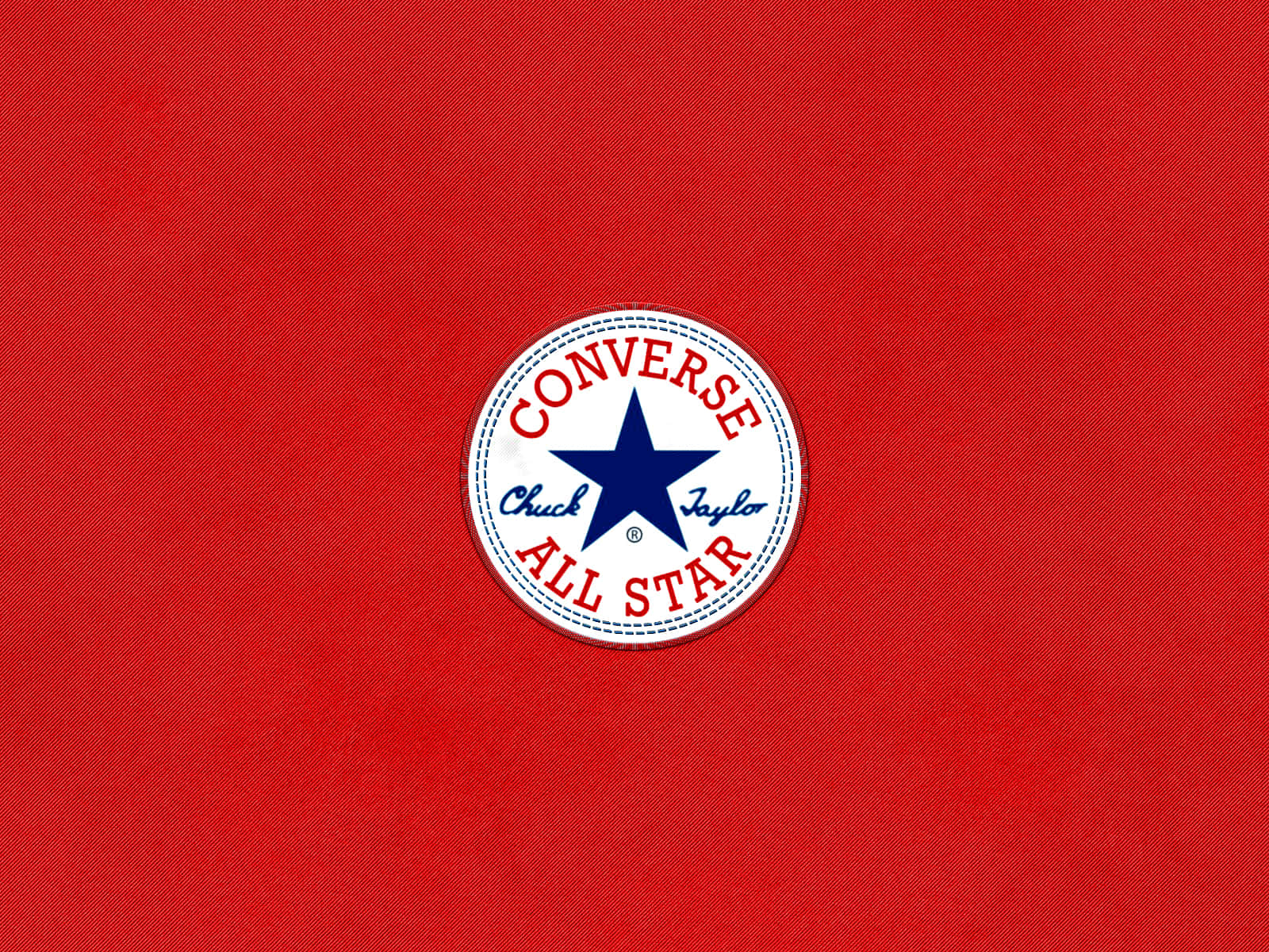 Converse Logo 桌布 壁紙 — 經典 Converse All Star 標誌貼布，置中於有紋理的紅色布料背景上。