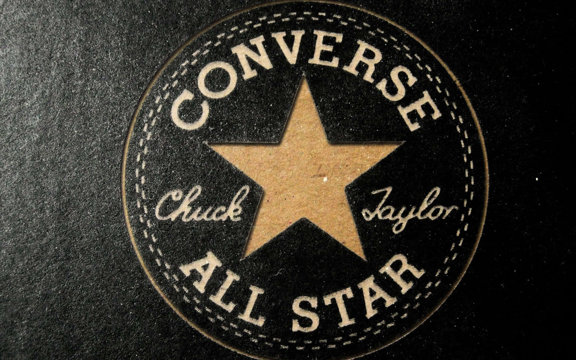 Converse 標誌 桌布 壁紙 — 經典 Converse Chuck Taylor All Star 標誌布章在紋理黑色布料上的特寫。