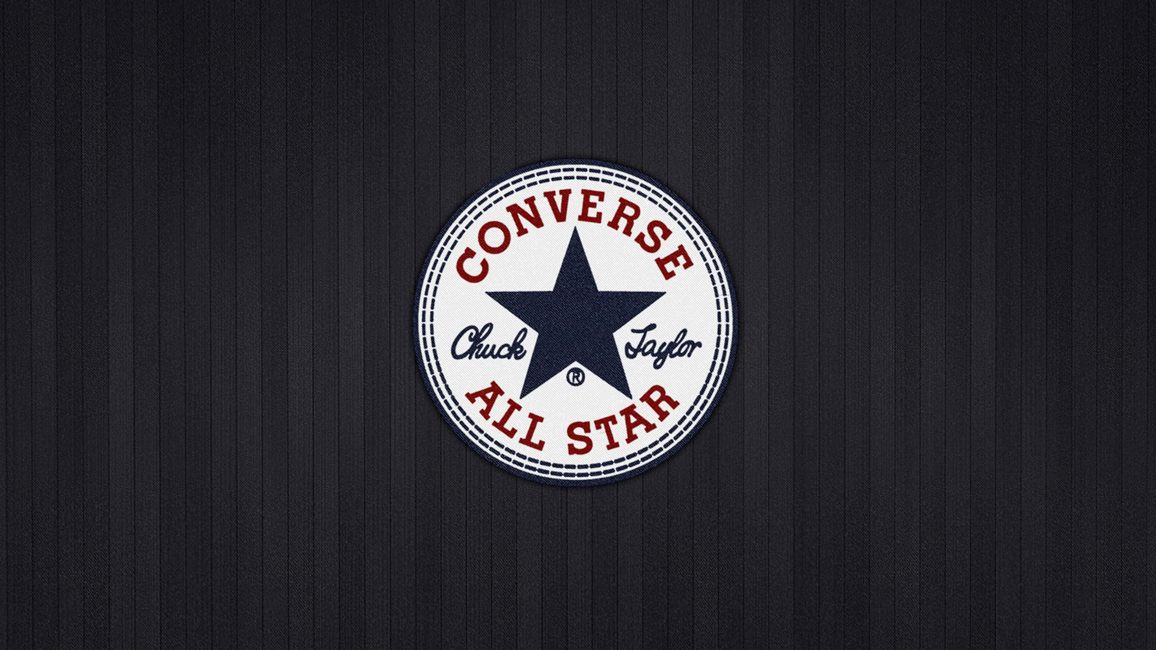 Converse Logo 桌布 壁紙 — 經典 Converse Chuck Taylor All Star 標誌置於深色紋理條紋背景中央。