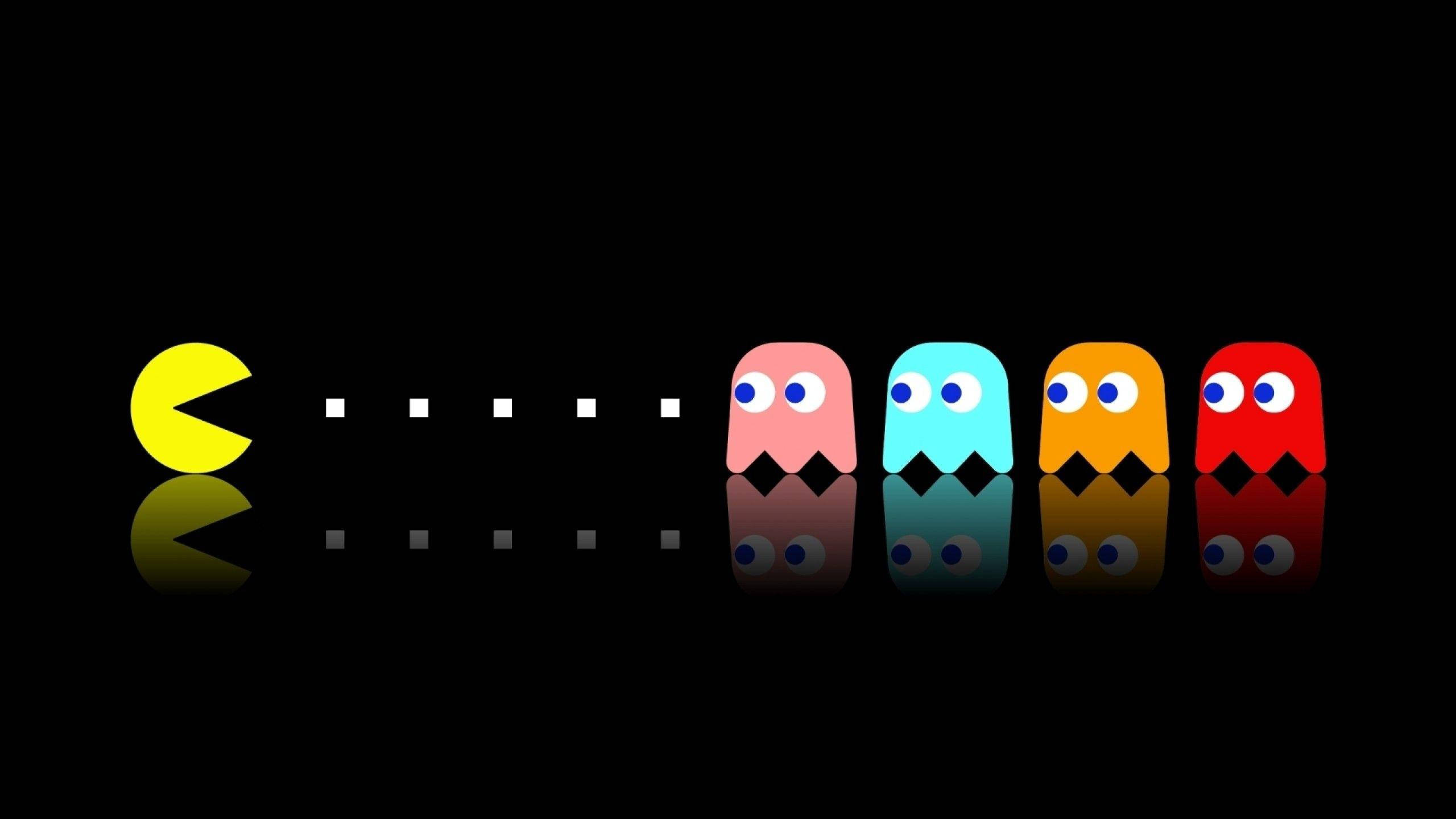 Pacman 桌布 壁紙 — 經典 Pacman 與四個彩色鬼魂站在黑色背景上，帶有微妙的反射效果，排成一列。