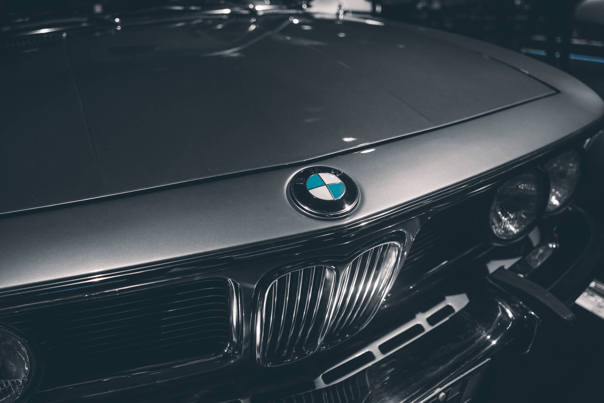 BMW 動圖 桌布 壁紙 — 經典BMW汽車引擎蓋和標誌性雙腎型水箱護罩的特寫，在氣氛燈光下。