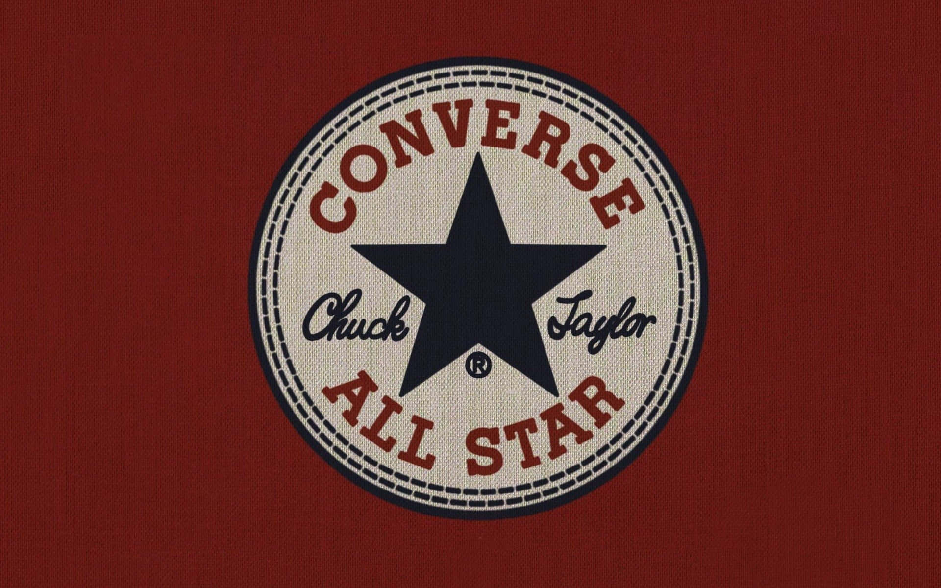Converse 標誌 桌布 壁紙 — 經典Converse Chuck Taylor All Star標誌貼片，位於紋理紅色布料上，帶有海軍藍星星和紅色文字。