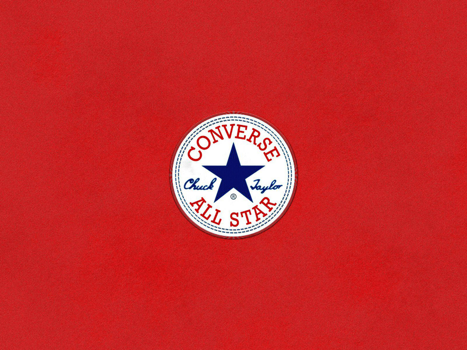 Converse 標誌 桌布 壁紙 — 經典Converse Chuck Taylor All Star標誌置於有紋理的紅色布料背景中央。