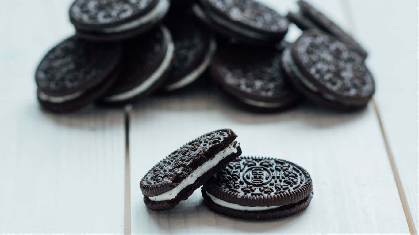 1366x768 Cookies 桌布 壁紙 — 經典Oreo餅乾堆疊，帶有奶油夾心，放在明亮的白色木質表面上。