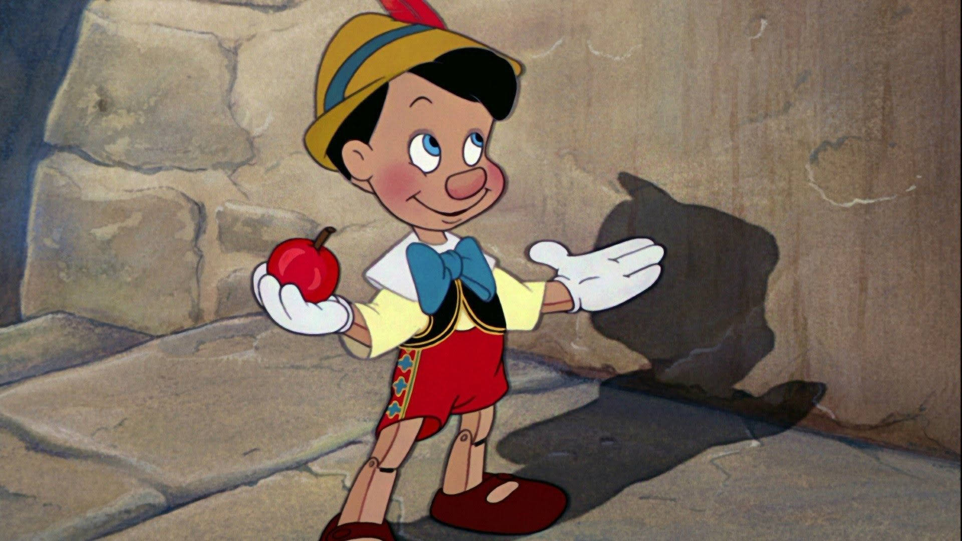 Pinocchio 桌布 壁紙 — 經典動畫小木偶皮諾丘在溫暖燈光下，於石牆背景前拿著一個紅蘋果。