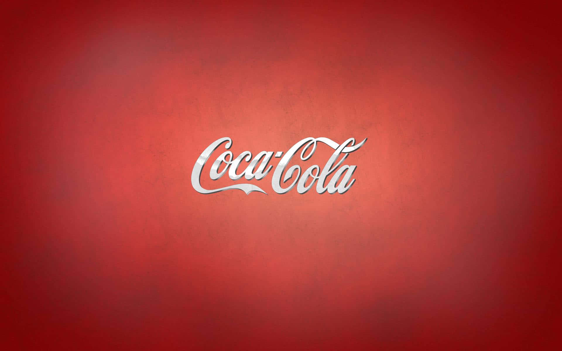 coca cola 桌布 壁紙 — 經典可口可樂標誌，以銀色草書字體居中顯示在帶有紋理的深紅色漸變背景上。