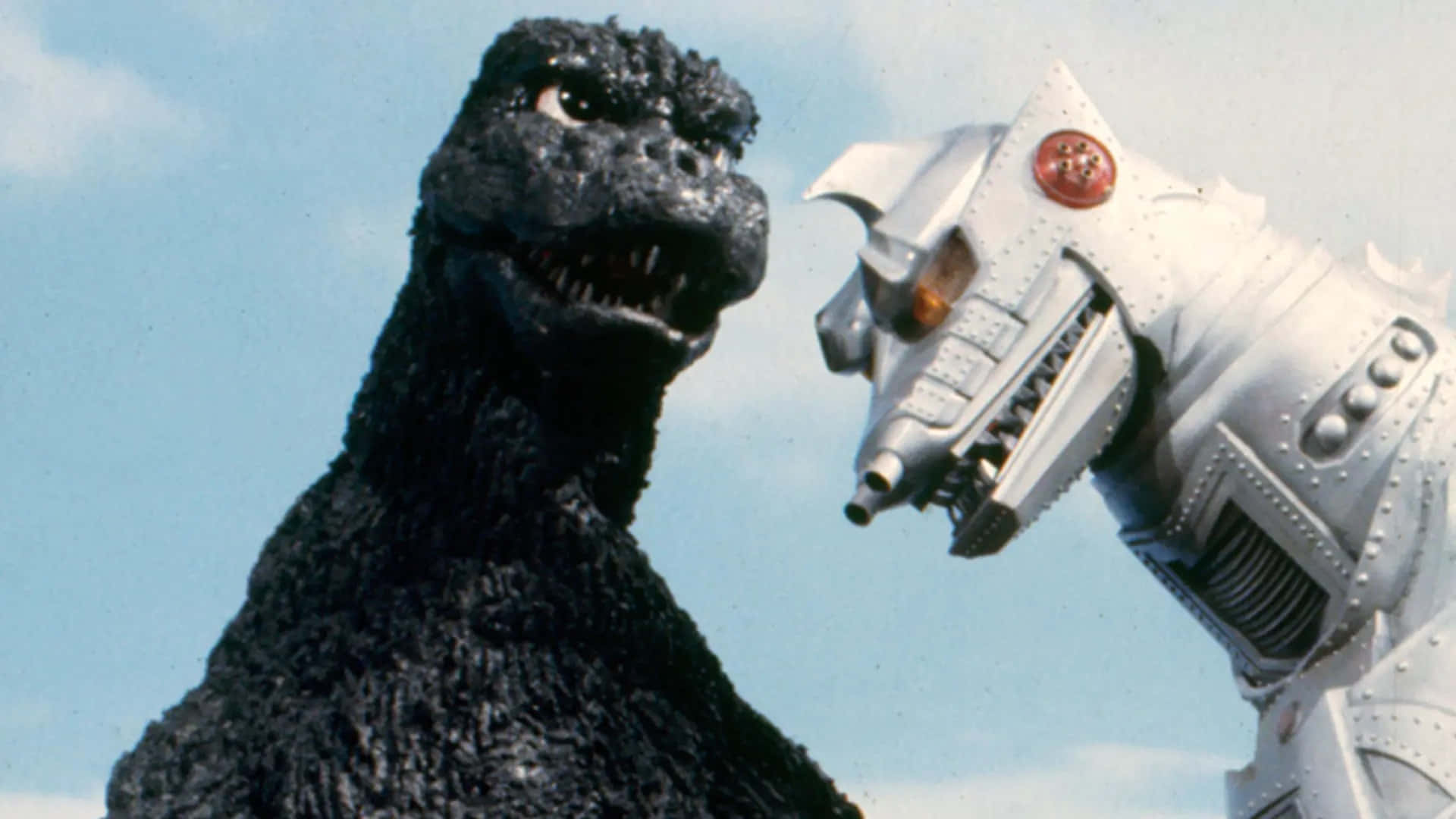 Godzilla Vs Mechagodzilla 桌布 壁紙 — 經典怪獸哥吉拉與銀色機器人王在戲劇性的天空對峙中對決。