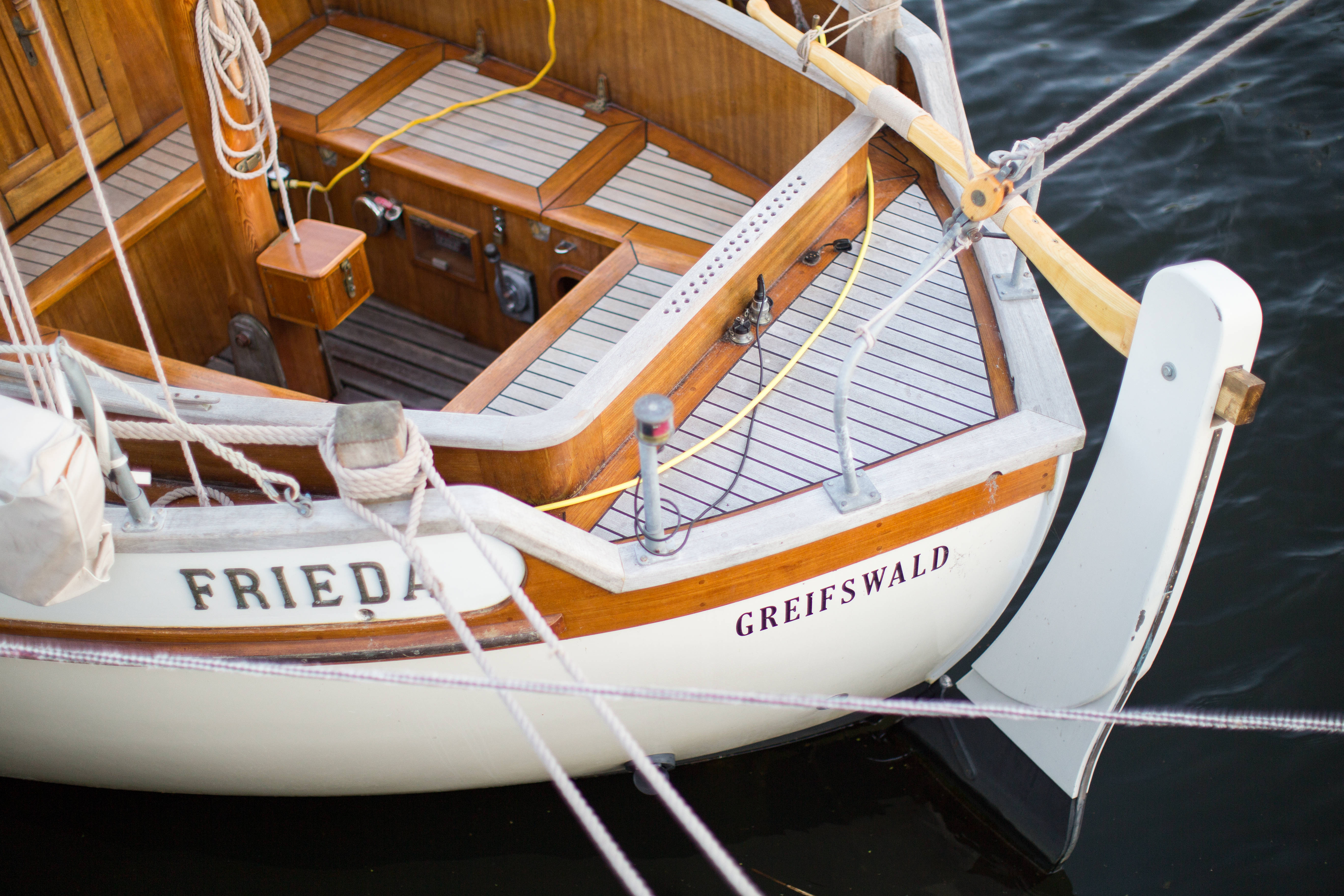 船 桌布 壁紙 — 經典木製帆船名為 'Frieda' 的船身上有 'Greifswald' 字樣，漂浮在平靜的深色水面上，特寫鏡頭。