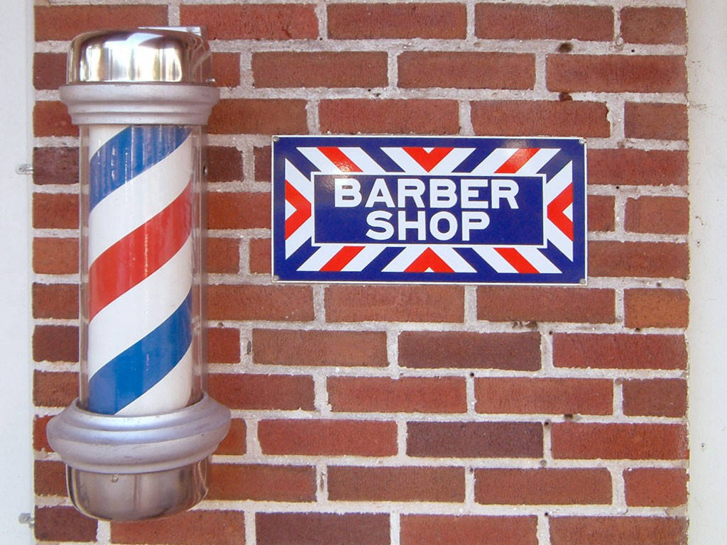 Barber 桌布 壁紙 — 經典理髮柱和招牌安裝在紅磚牆上，帶有白色砂漿。