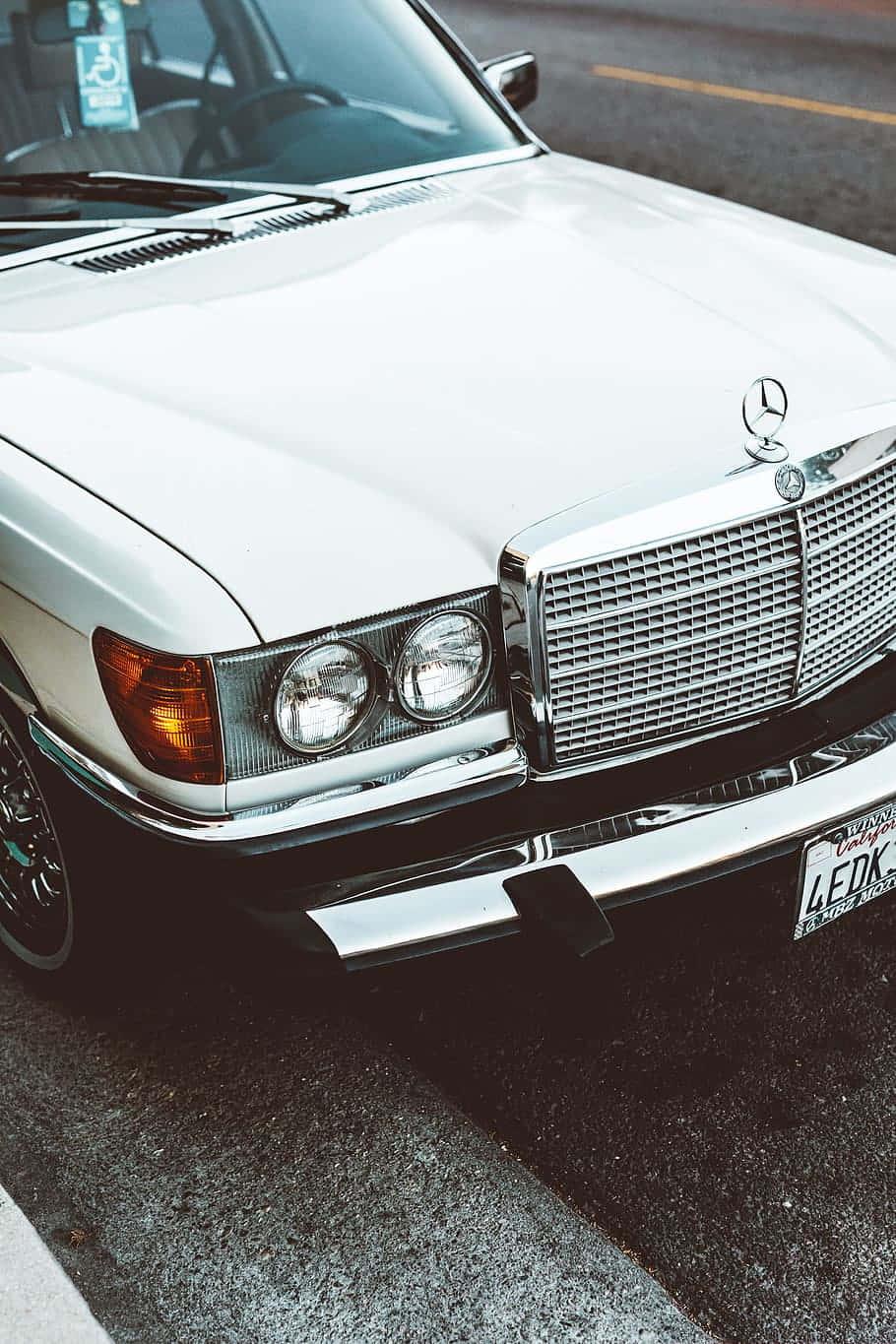Mercedes 桌布 壁紙 — 經典白色賓士近距離特寫，配備鍍鉻水箱護罩及圓形頭燈，停泊在柏油路上。