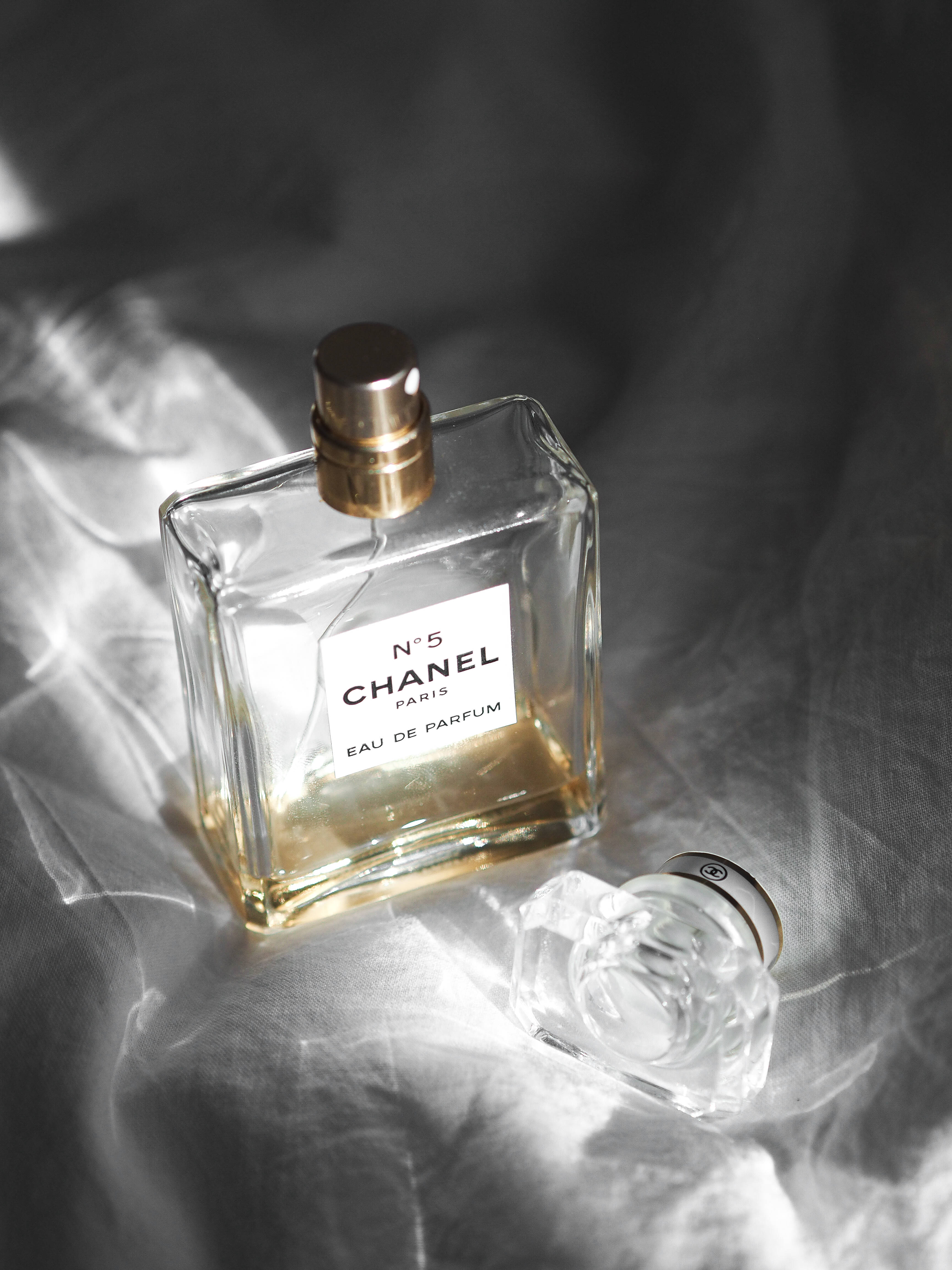 Chanel 桌布 壁紙 — 經典的 Chanel No 5 香水瓶優雅地放置在皺褶銀色布料上，柔和的方向光照射。