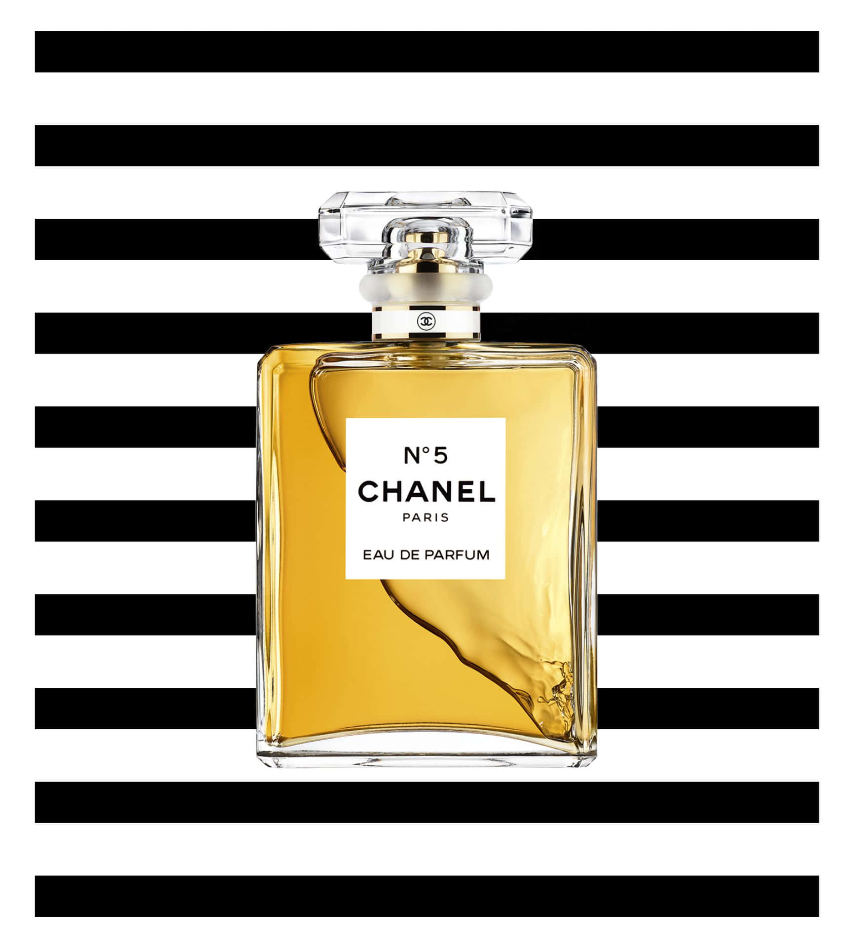 Chanel 桌布 壁紙 — 經典的Chanel No 5香水瓶，內有金色液體，置於大膽的黑白橫條紋背景中央。