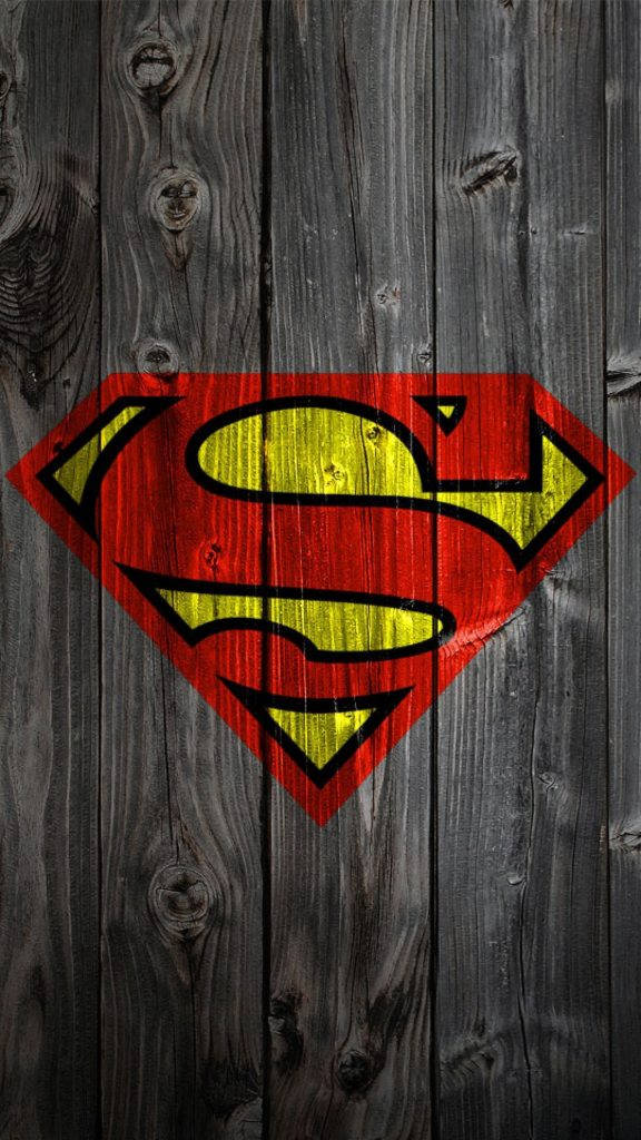 superman iPhone 桌布 壁紙 — 經典的超人標誌以鮮明的紅色和黃色繪製在經風化的灰色木板上。