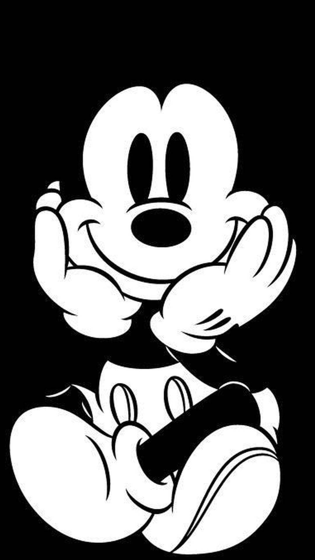 Mickey 桌布 壁紙 — 經典米奇老鼠以醒目的黑白配色，雙手舉起，愉快地坐在純黑色背景前。