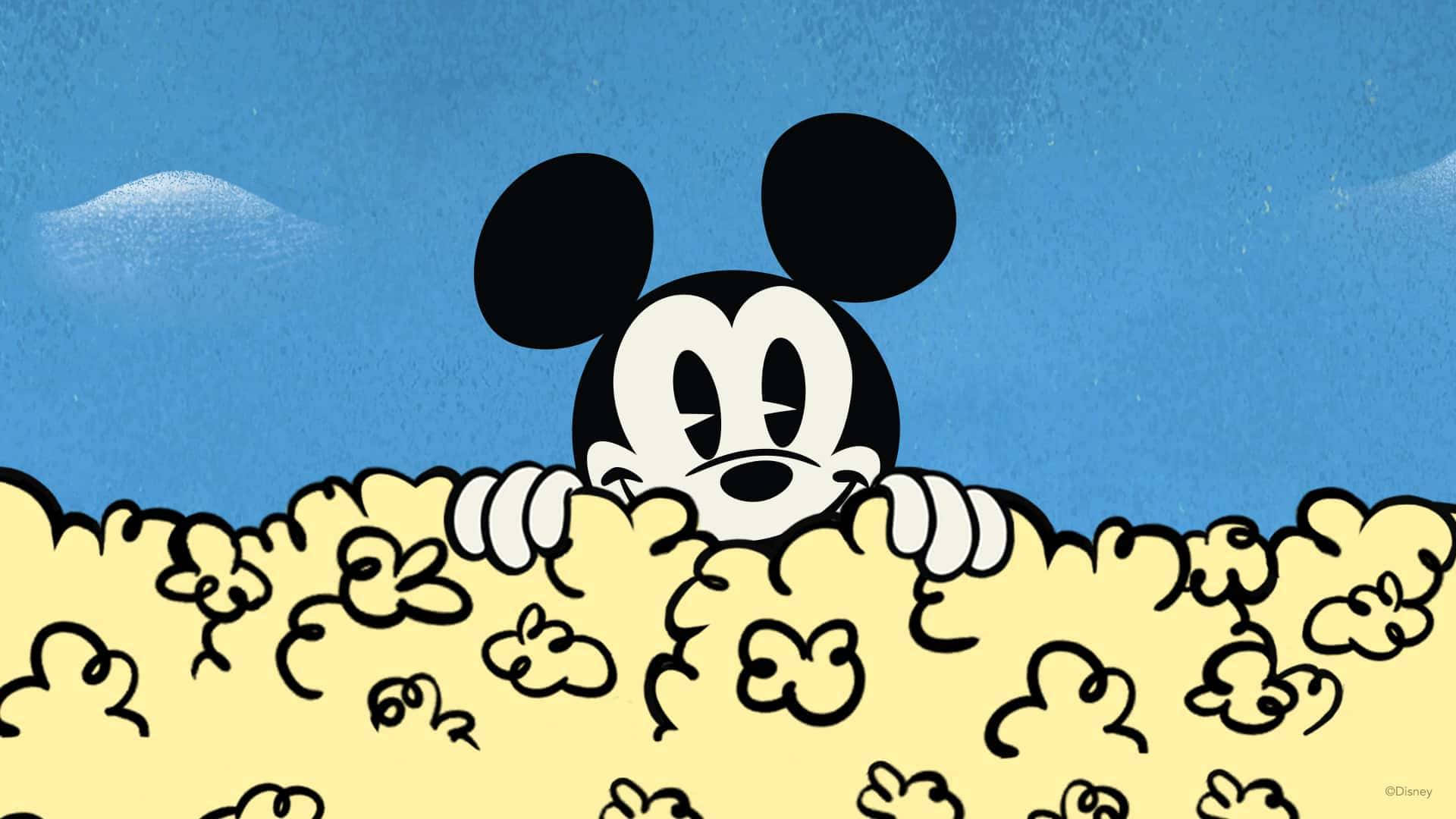 Mickey Mouse Cool 桌布 壁紙 — 經典米奇老鼠在一個有紋理的藍天白雲背景下，頑皮地在一座黃色爆米花山上面探出頭來。