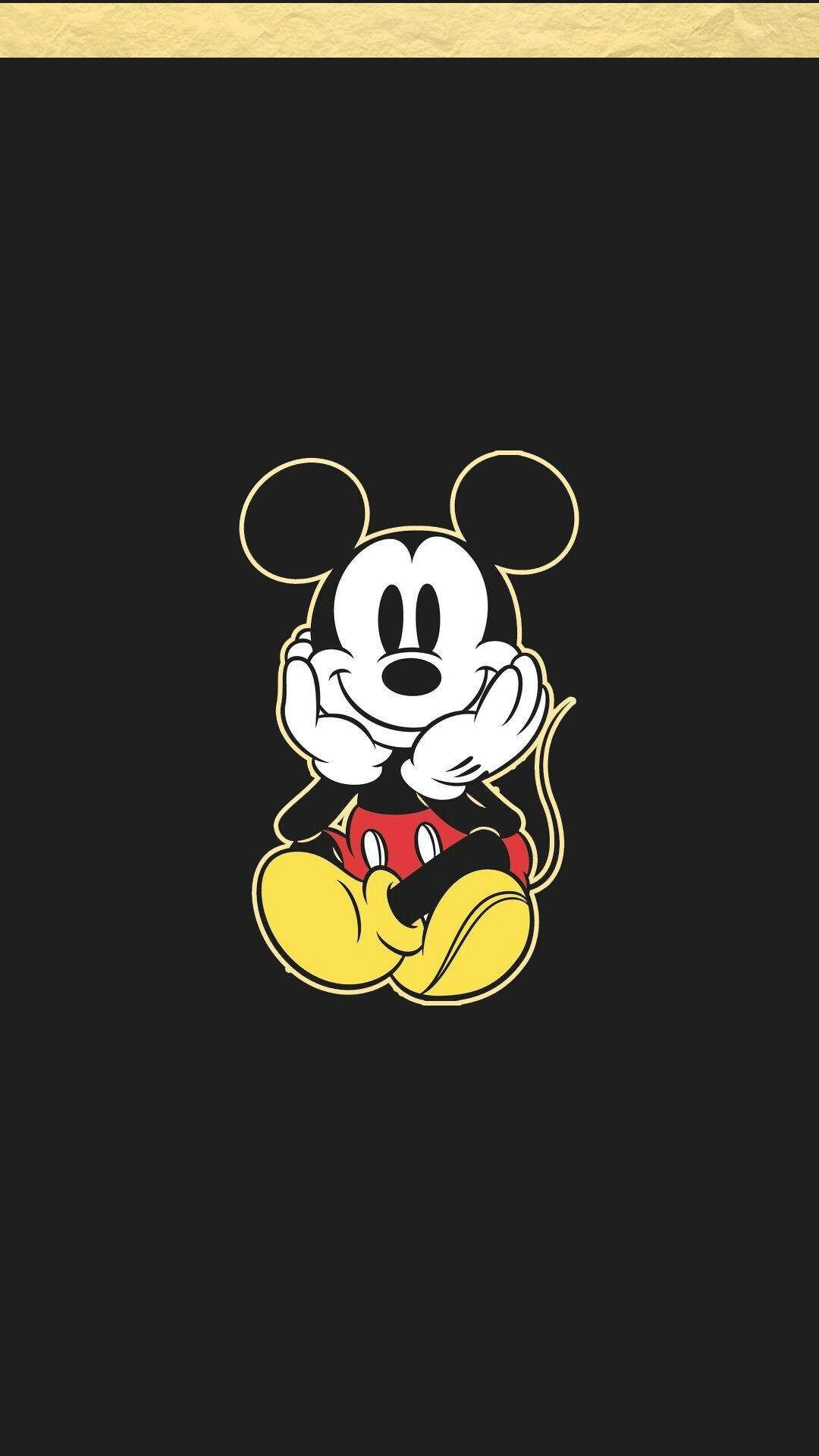 Mickey 桌布 壁紙 — 經典米奇老鼠微笑著雙手合十坐在黑色背景上，帶有金色邊框。