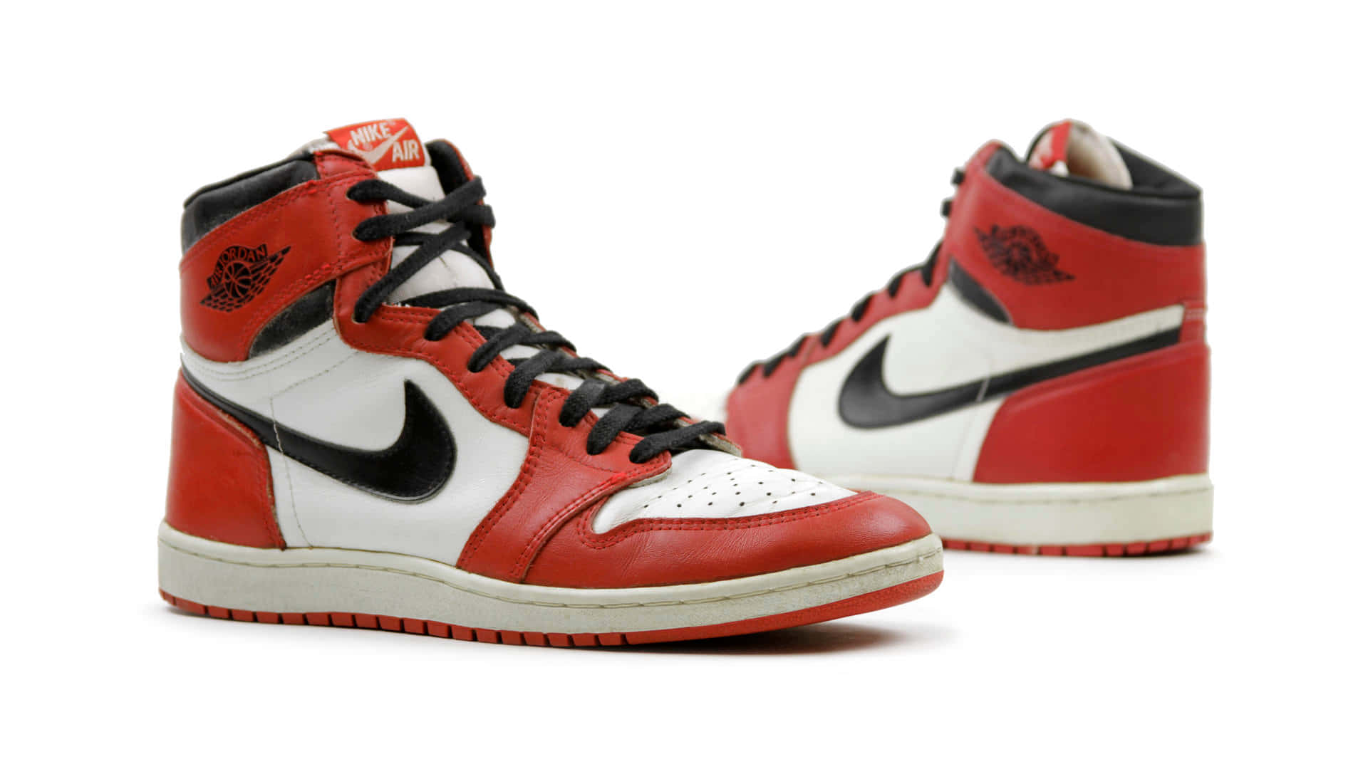 Air Jordan 1 桌布 壁紙 — 經典紅白黑高筒運動鞋，帶有標誌性 swoosh 和 wing 標誌，背景為純白色。