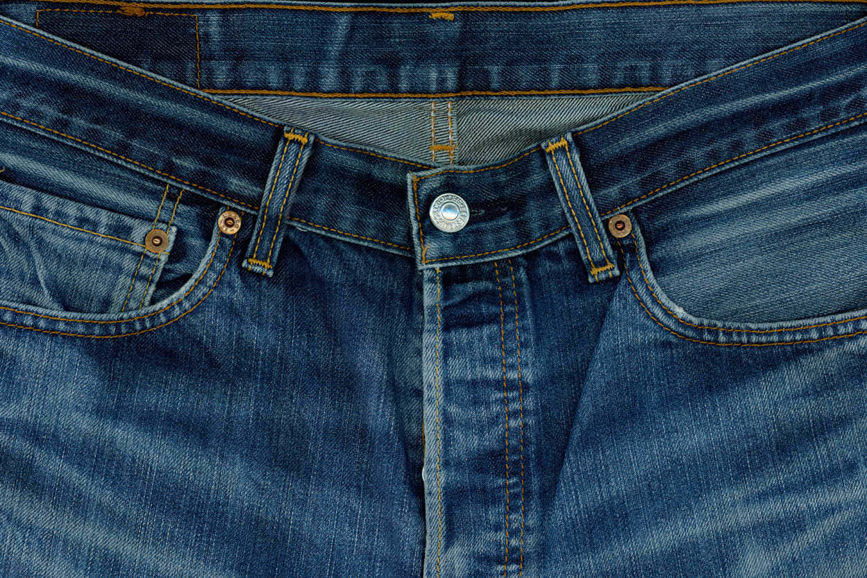 Jeans 桌布 壁紙 — 經典藍色牛仔褲的特寫，顯示詳細的縫線、鈕扣和磨損質感。