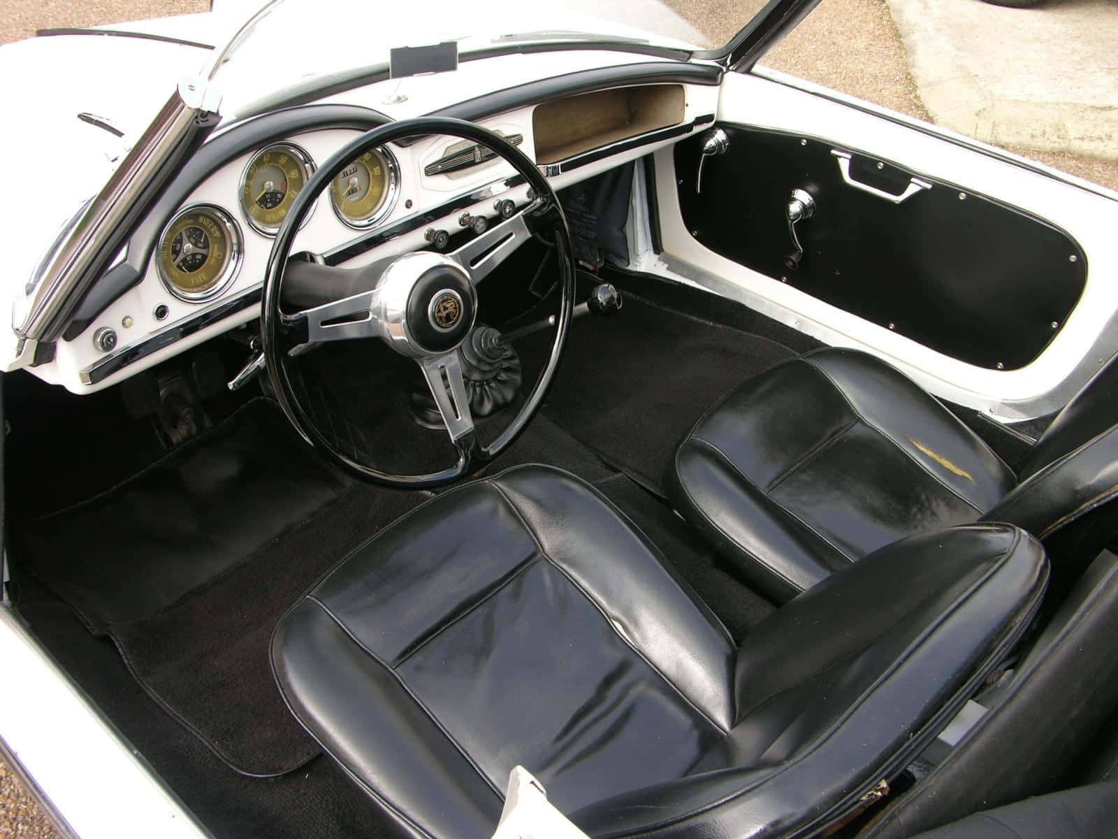 Alfa Romeo Spider 桌布 壁紙 — 經典跑車內裝，配備黑色皮革座椅和鍍鉻儀表板，帶有經典圓形儀表。
