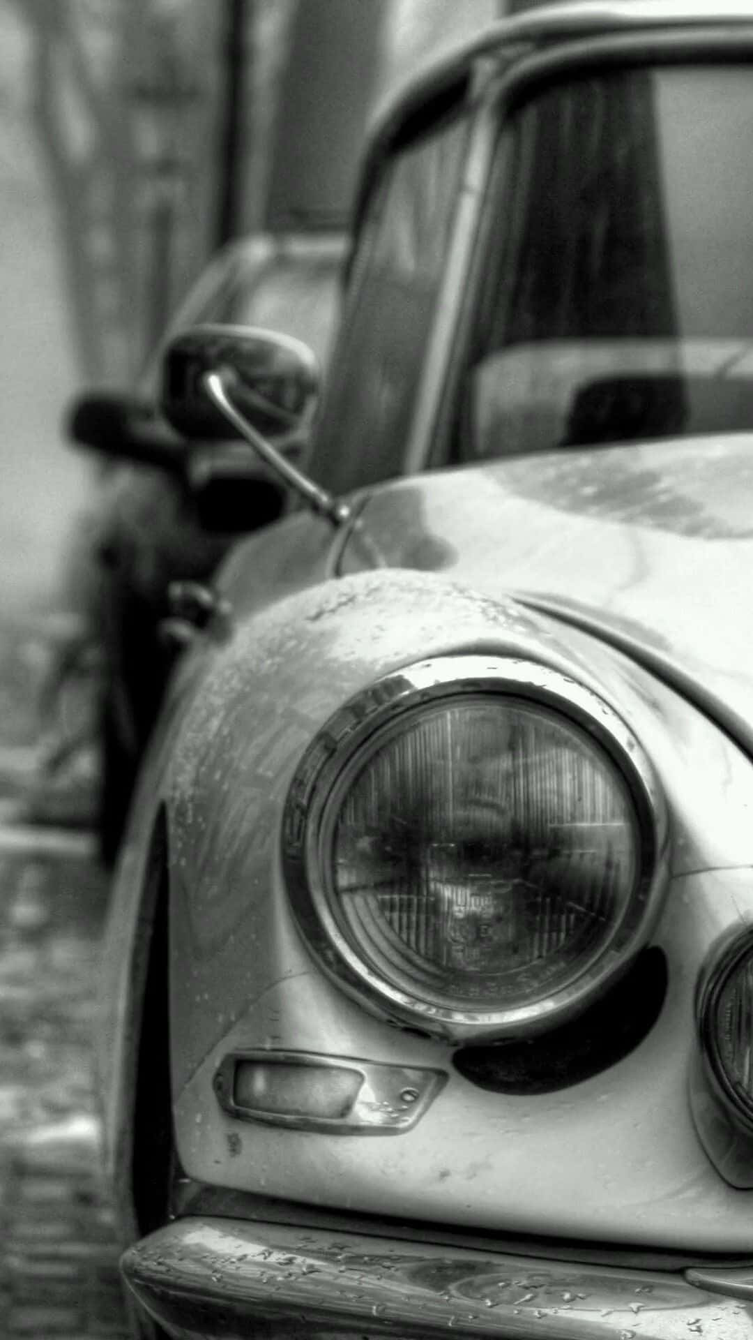Monochrome 桌布 壁紙 — 經典車風化前端的黑白特寫，圓形頭燈和引擎蓋上的雨滴。