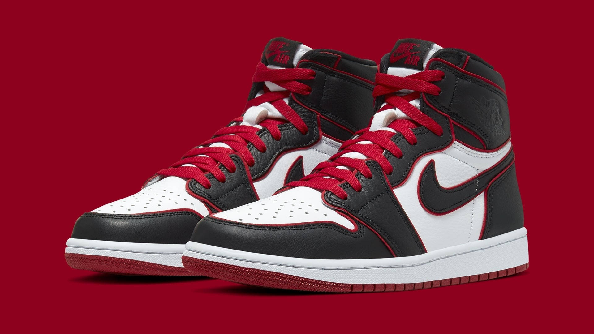 Nike Air Jordan 1 桌布 壁紙 — 經典高筒運動鞋（黑、白、紅）在純深紅色背景上大膽呈現。