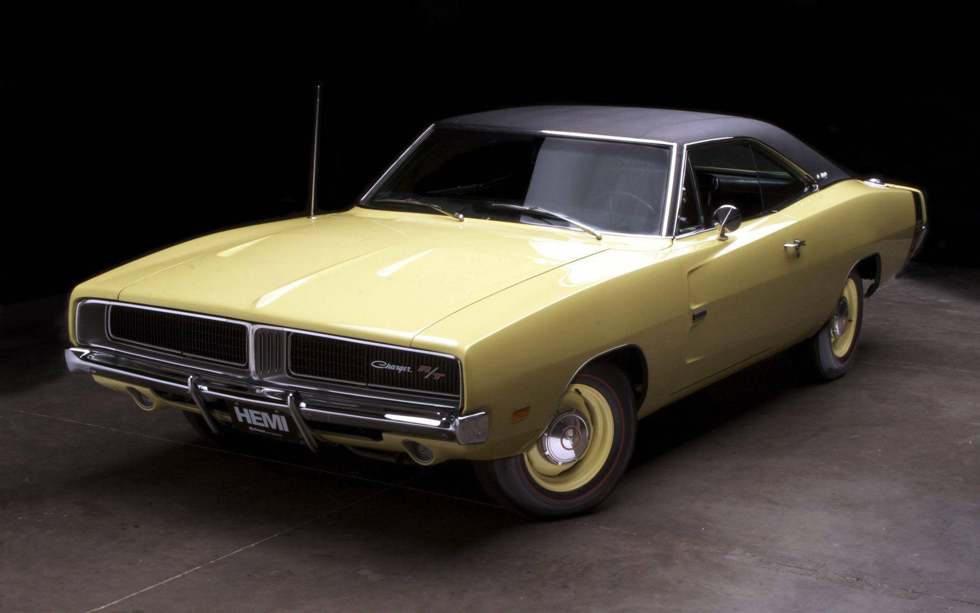 Charger 桌布 壁紙 — 經典黃色 Dodge Charger HEMI，配黑色乙烯基車頂和鍍鉻細節，在深色工作室背景下擺姿勢。