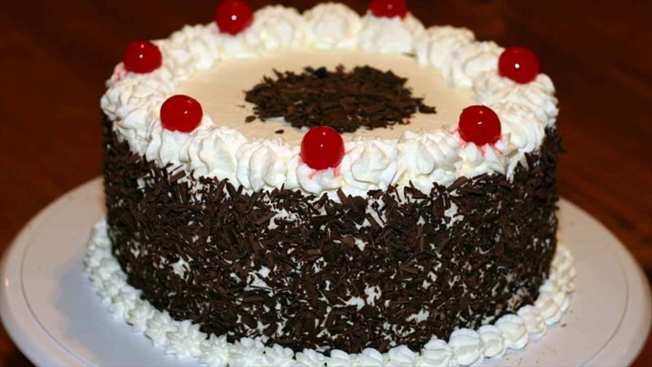 Black Forest Cake 桌布 壁紙 — 經典黑森林蛋糕，上面飾有鮮奶油、巧克力碎片和鮮紅櫻桃。