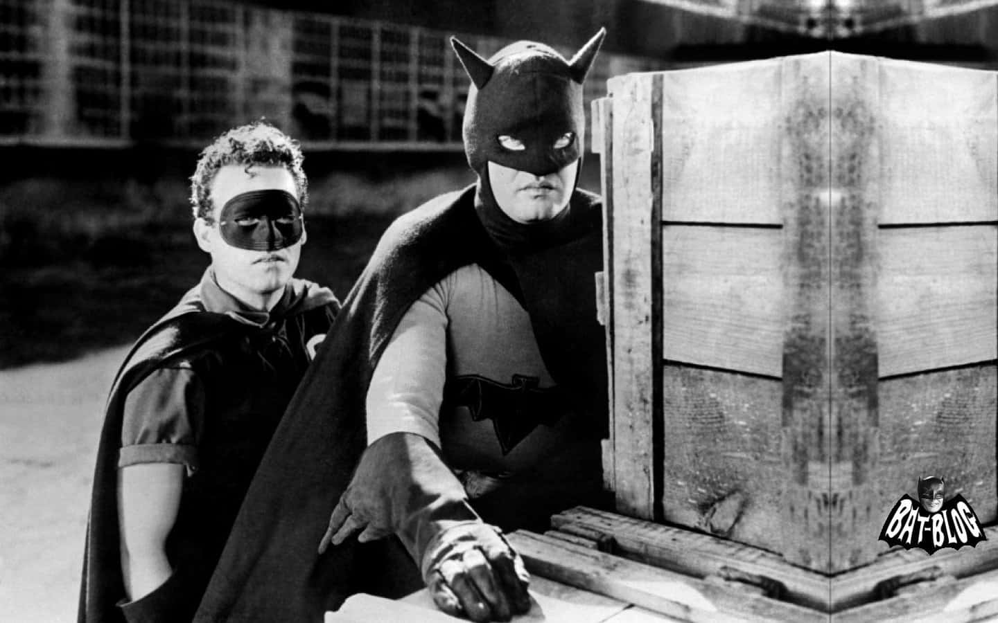 Batman Black And White 桌布 壁紙 — 經典黑白電影劇照，蝙蝠俠和羅賓穿著復古斗篷和面具，旁邊有一個木箱。