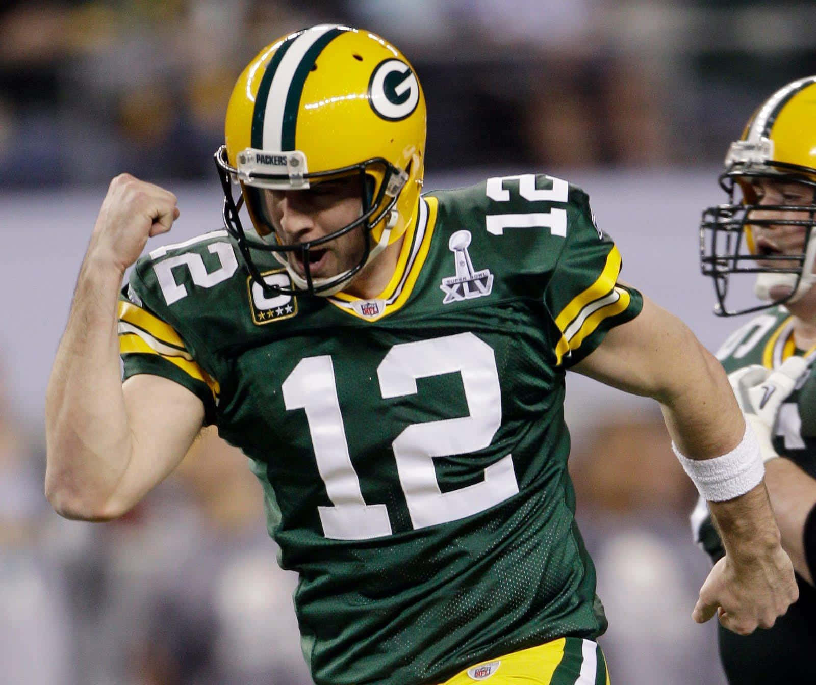 Aaron Rodgers 桌布 壁紙 — 綠灣包裝工的四分衛身穿綠色和金色球衣，在超級盃勝利中握拳慶祝。