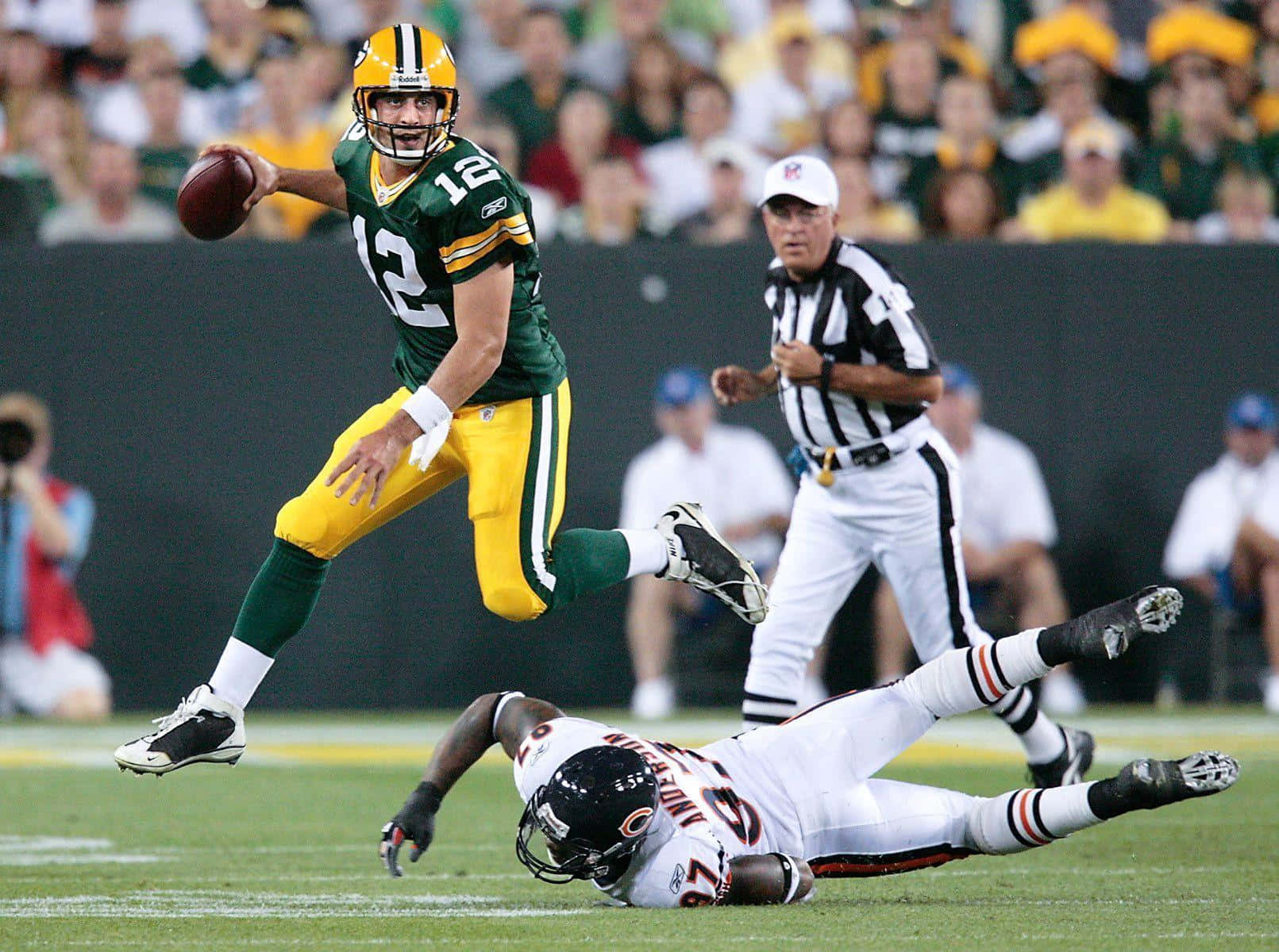 Aaron Rodgers 桌布 壁紙 — 綠灣包裝工隊的四分衛跳起傳球，而芝加哥熊隊的防守球員在夜間NFL比賽中飛身擒抱。