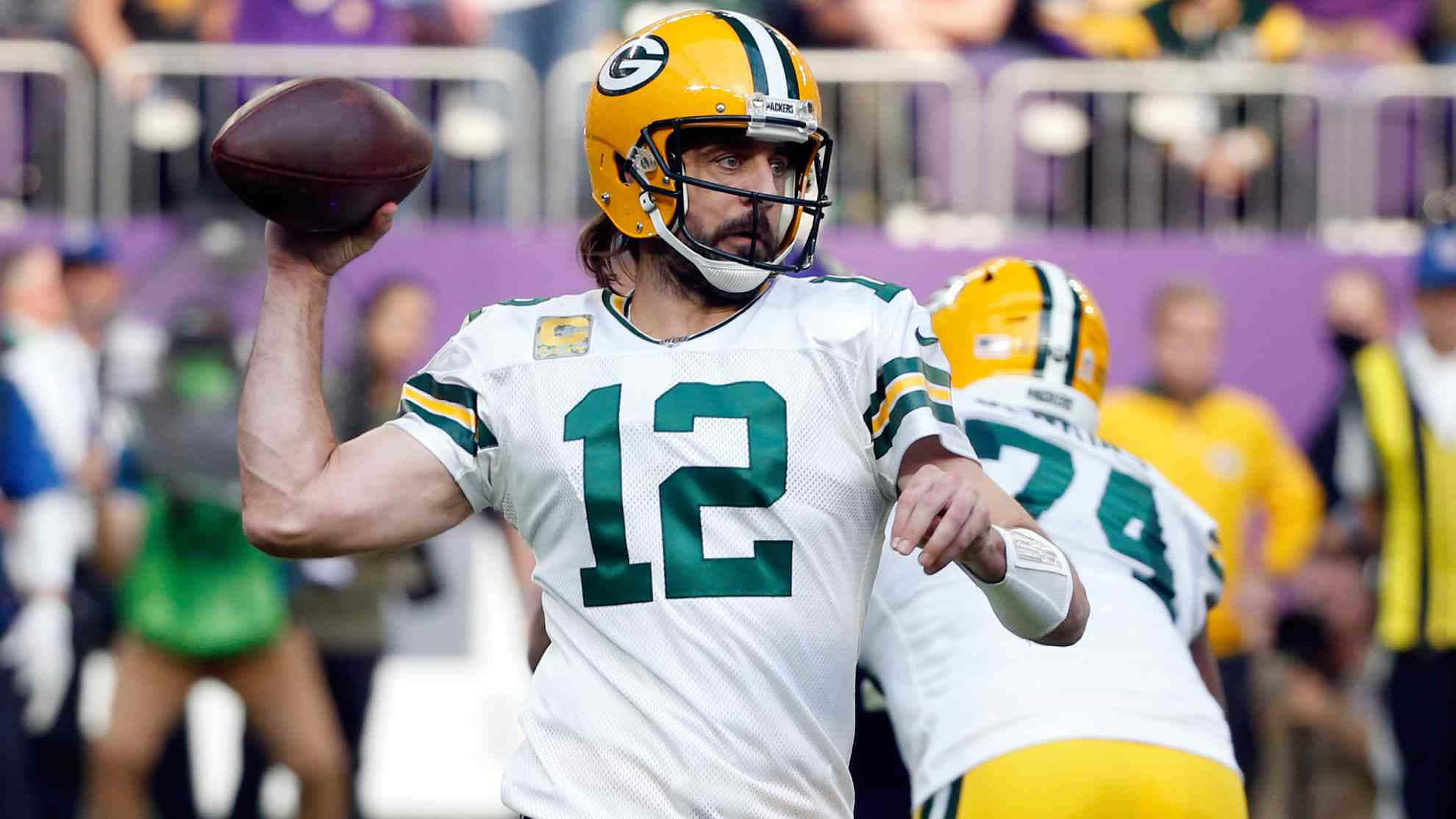 Aaron Rodgers 桌布 壁紙 — 綠灣包裝工隊的四分衛身穿白色和綠色球衣，在日間比賽中揮臂準備傳球。