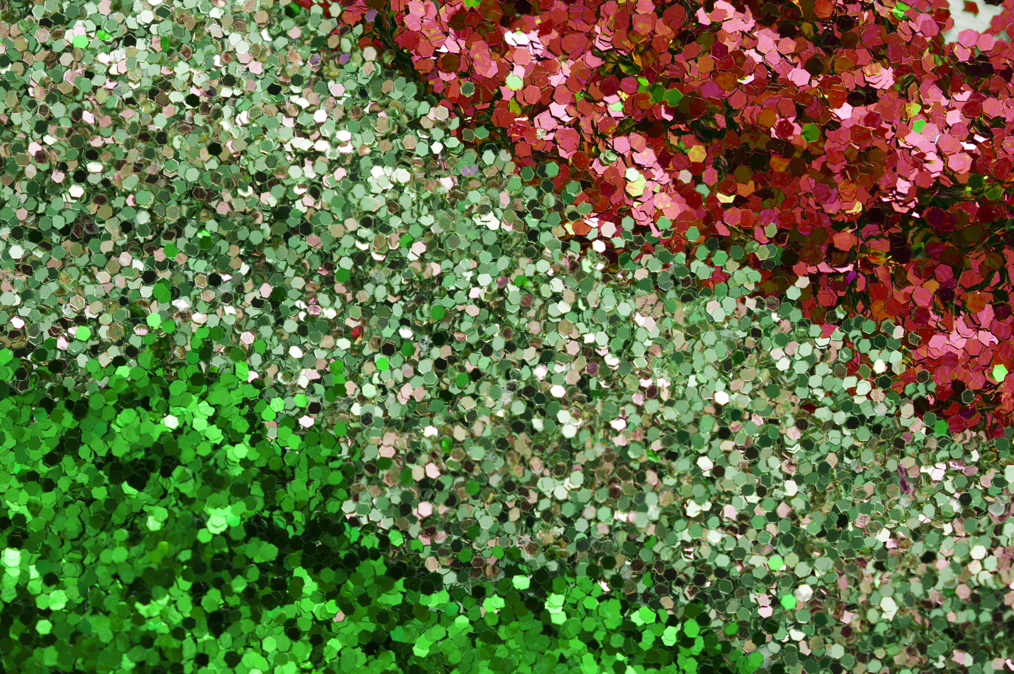 Green Glitter 桌布 壁紙 — 綠色、粉紅色和銀色六角形亮粉的鮮豔特寫，營造出閃閃發光的紋理表面。