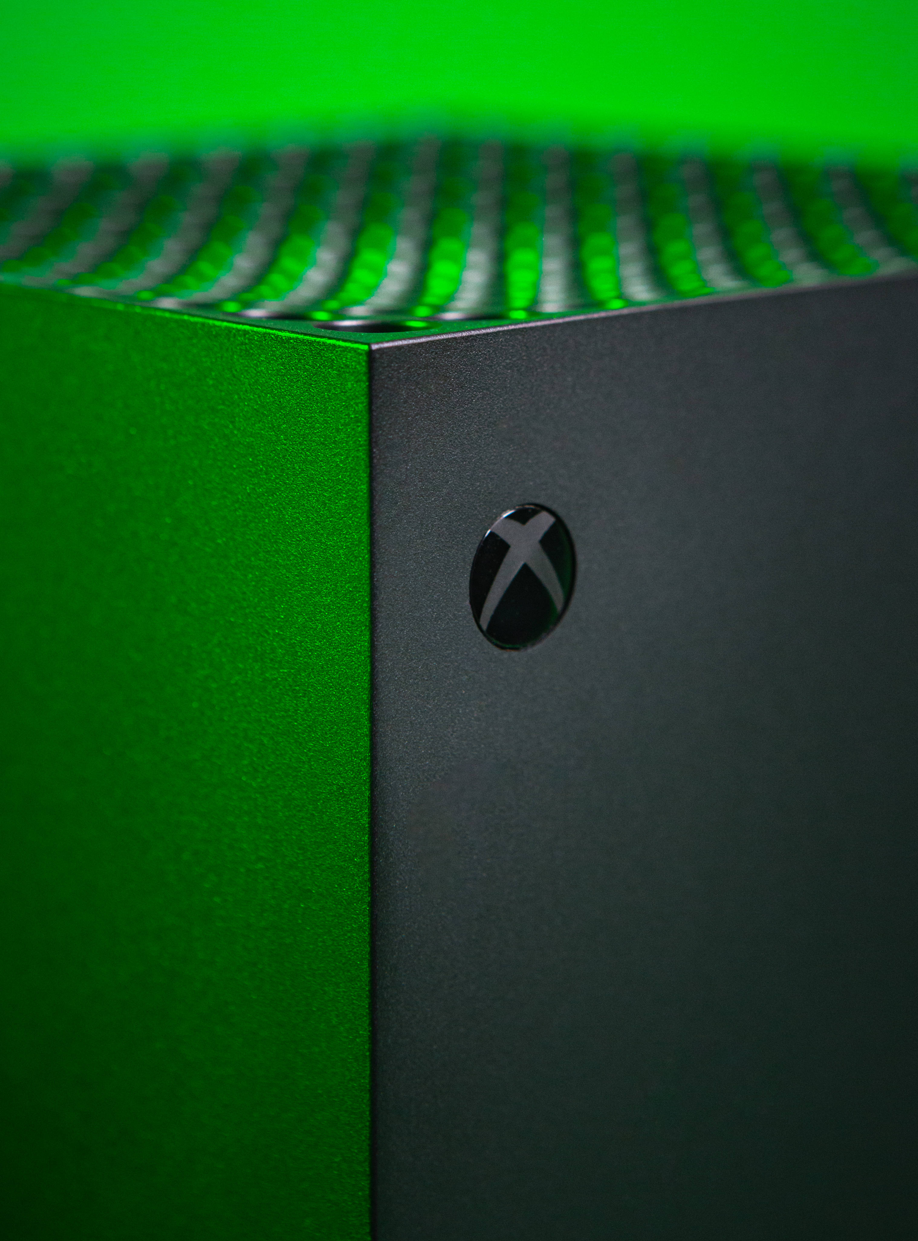 Xbox 桌布 壁紙 — 綠色Xbox主機特寫，帶有發光綠色通風口和霧面黑色飾面。
