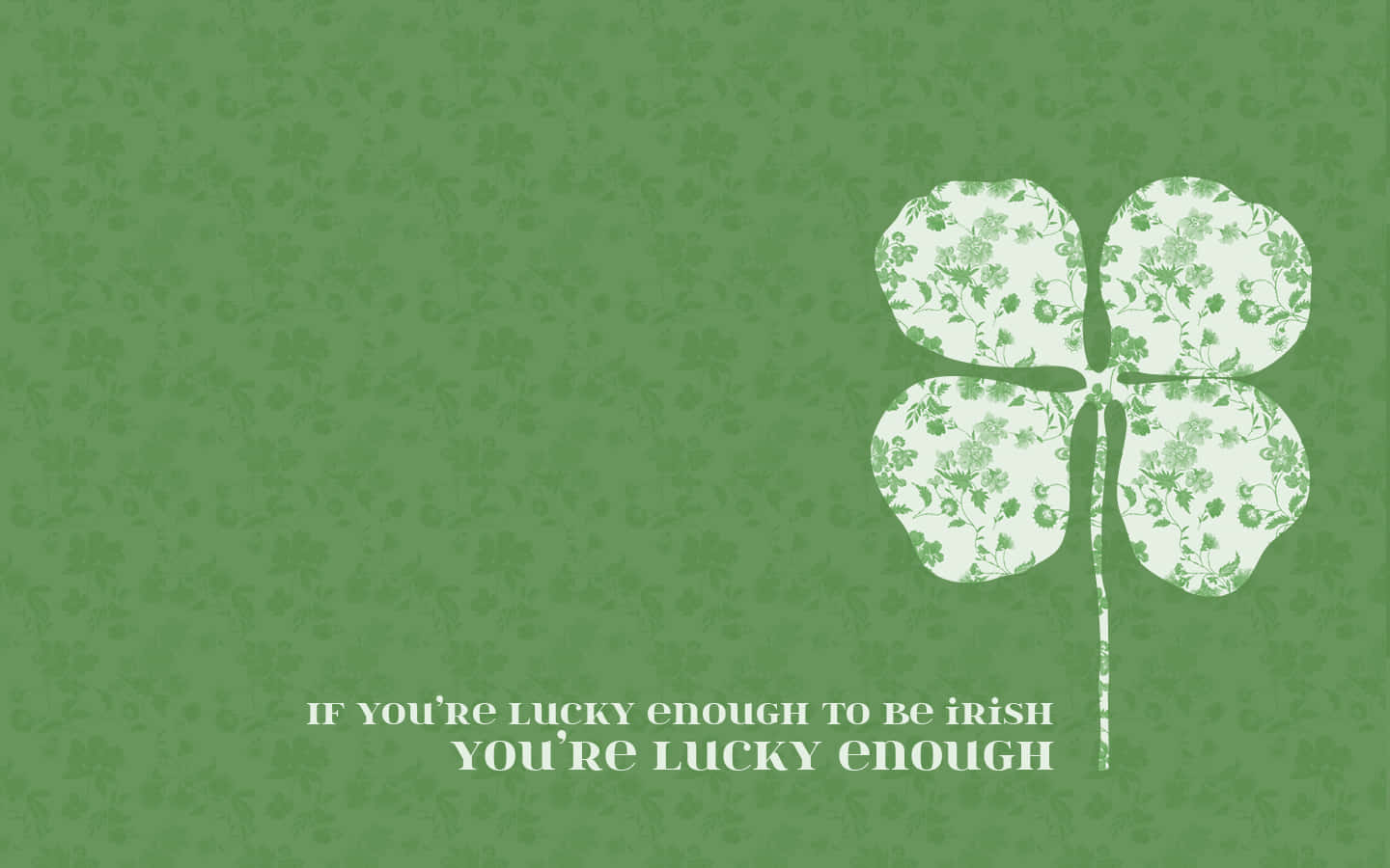 Celtic Irish 桌布 壁紙 — 綠色壁紙，上面有一個白色四葉草，充滿花卉圖案和慶祝愛爾蘭運氣的文字。