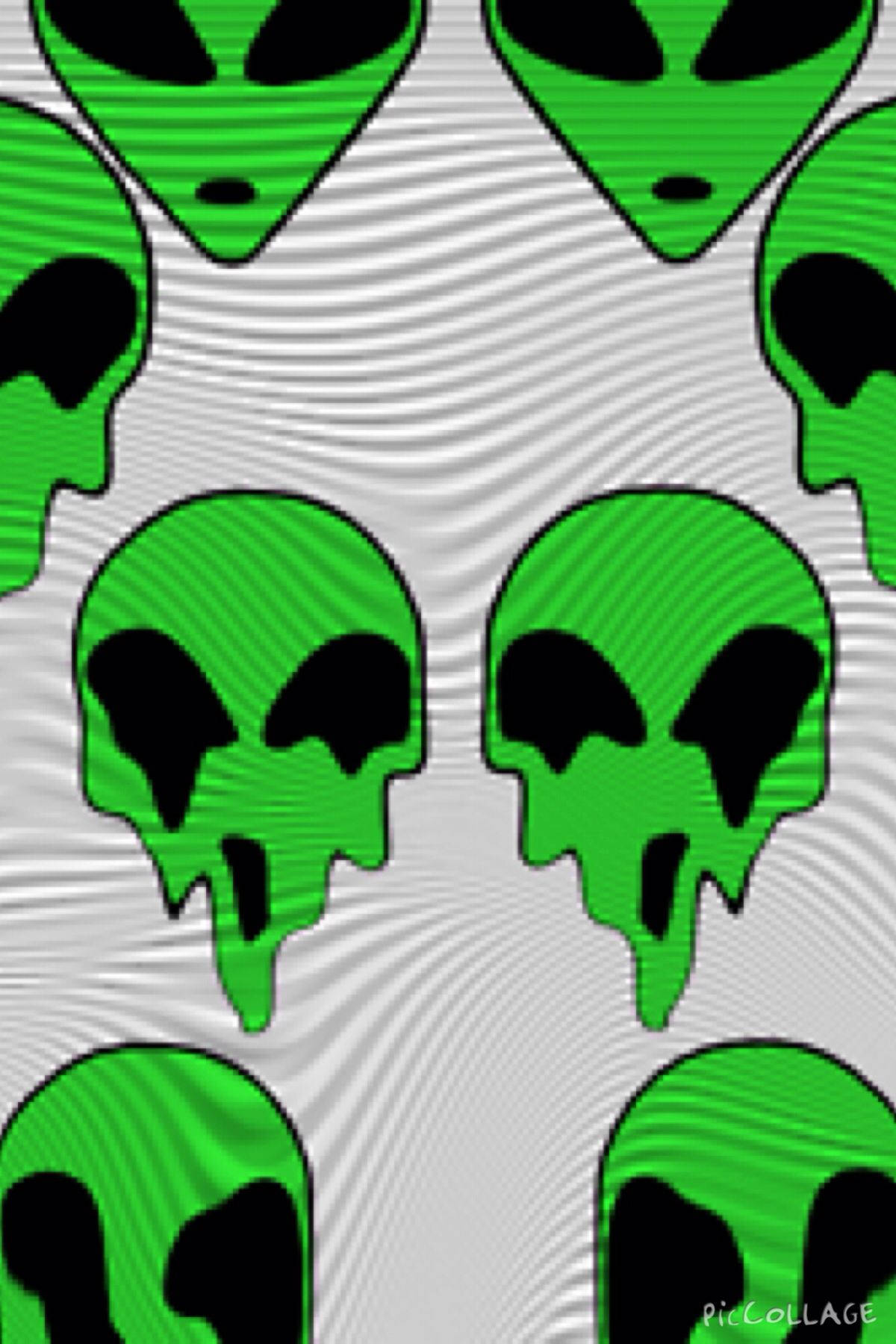 綠色外星人頭骨，帶有黑色眼窩和嘴巴，在波浪狀灰色背景上。