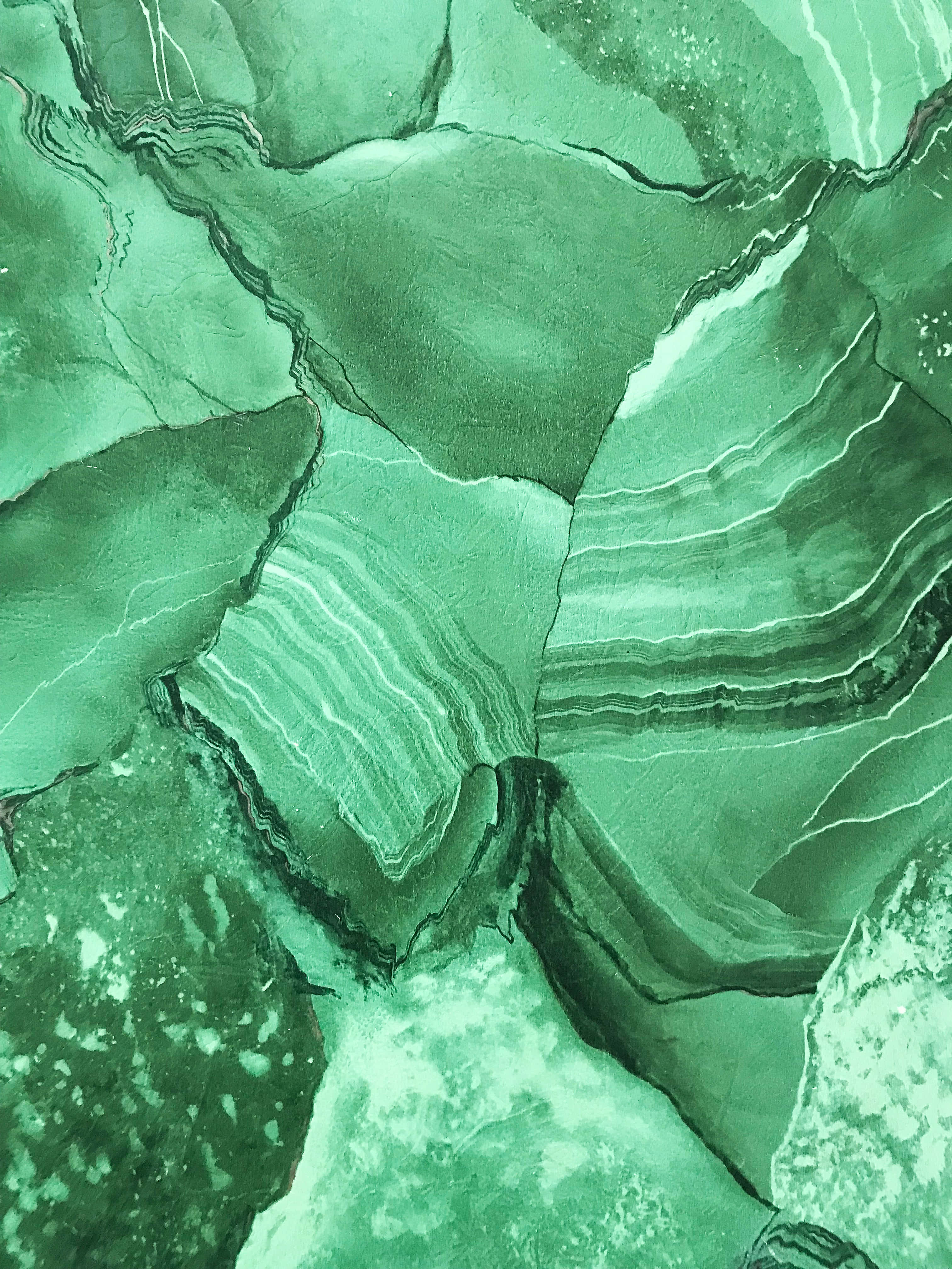 Olive Green iPhone 桌布 壁紙 — 綠色孔雀石的近距離特寫，展現出複雜的層狀紋理和自然裂縫。