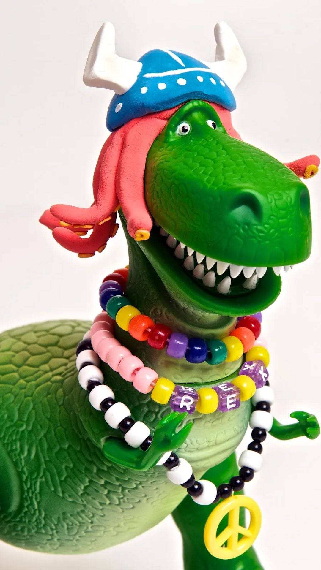 rex 桌布 壁紙 — 綠色恐龍公仔打扮成維京人，戴著彩色珠子和和平符吊墜。