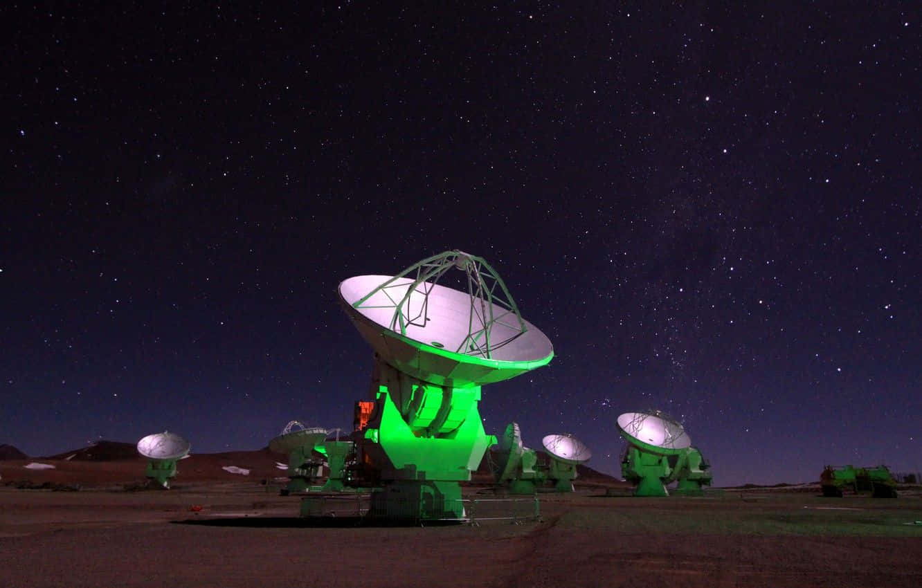 Radio Telescope 桌布 壁紙 — 綠色照明的無線電望遠鏡在繁星點點的沙漠夜空下靜靜佇立。