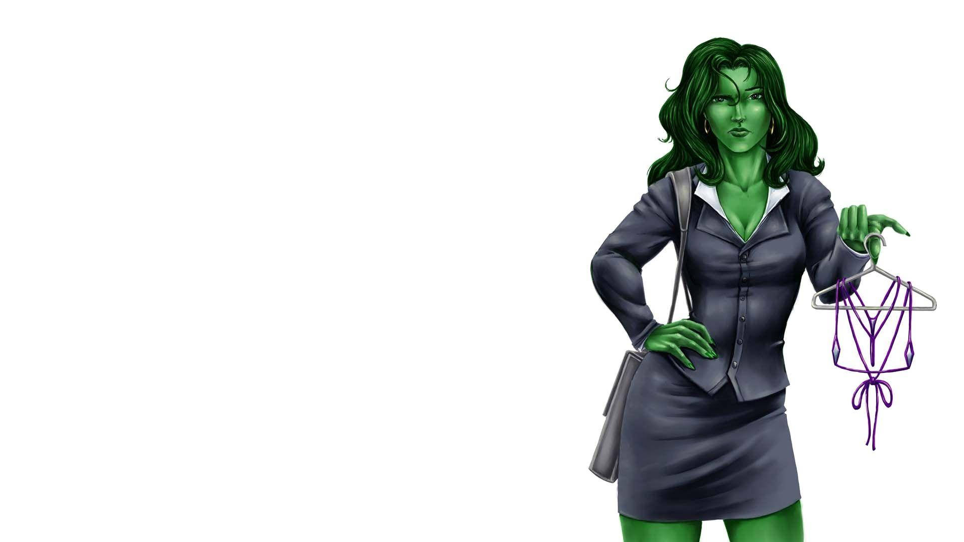 She Hulk 桌布 壁紙 — 綠色皮膚的女人穿著西裝，在白色背景前拿著掛有紫色內衣的衣架。