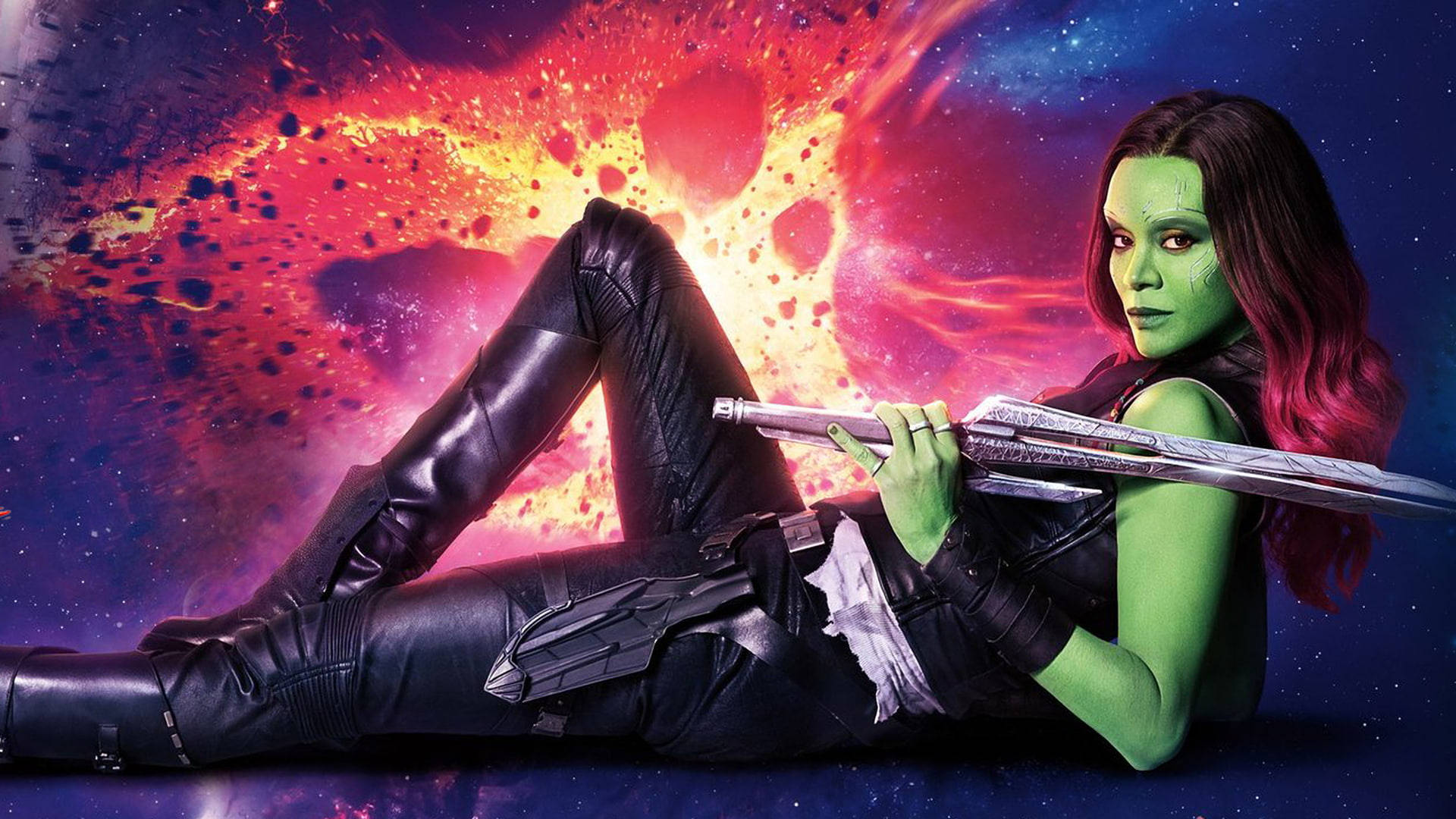 Zoe Saldana 桌布 壁紙 — 綠色皮膚的葛摩菈自信地躺在黑色皮衣中，背景是熾熱的宇宙星雲。