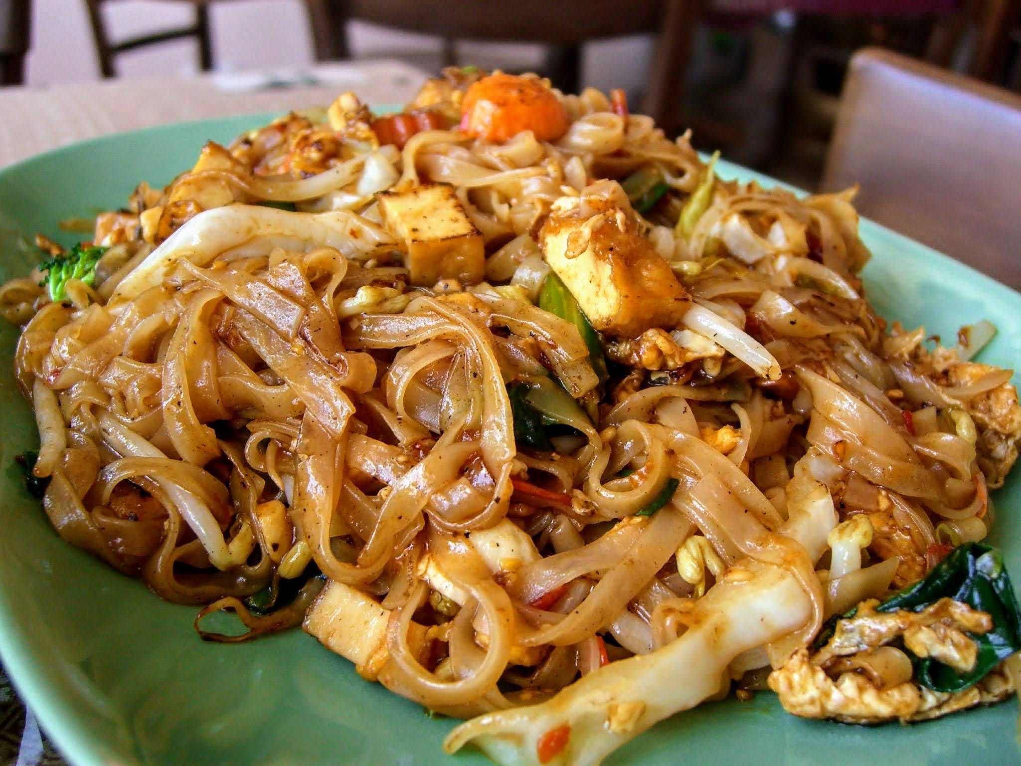 tofu 桌布 壁紙 — 綠色盤子上炒米粉配豆腐、花椰菜和胡蘿蔔的特寫。