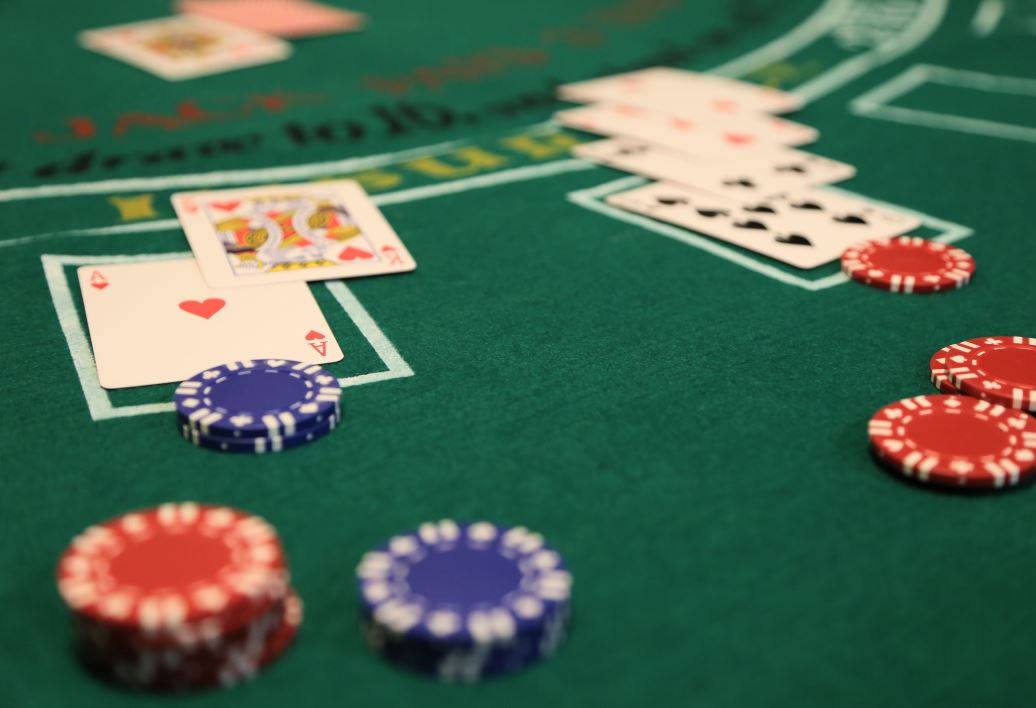 Casino 桌布 壁紙 — 綠色賭場賭桌上籌碼和撲克牌的特寫，帶有投注區。