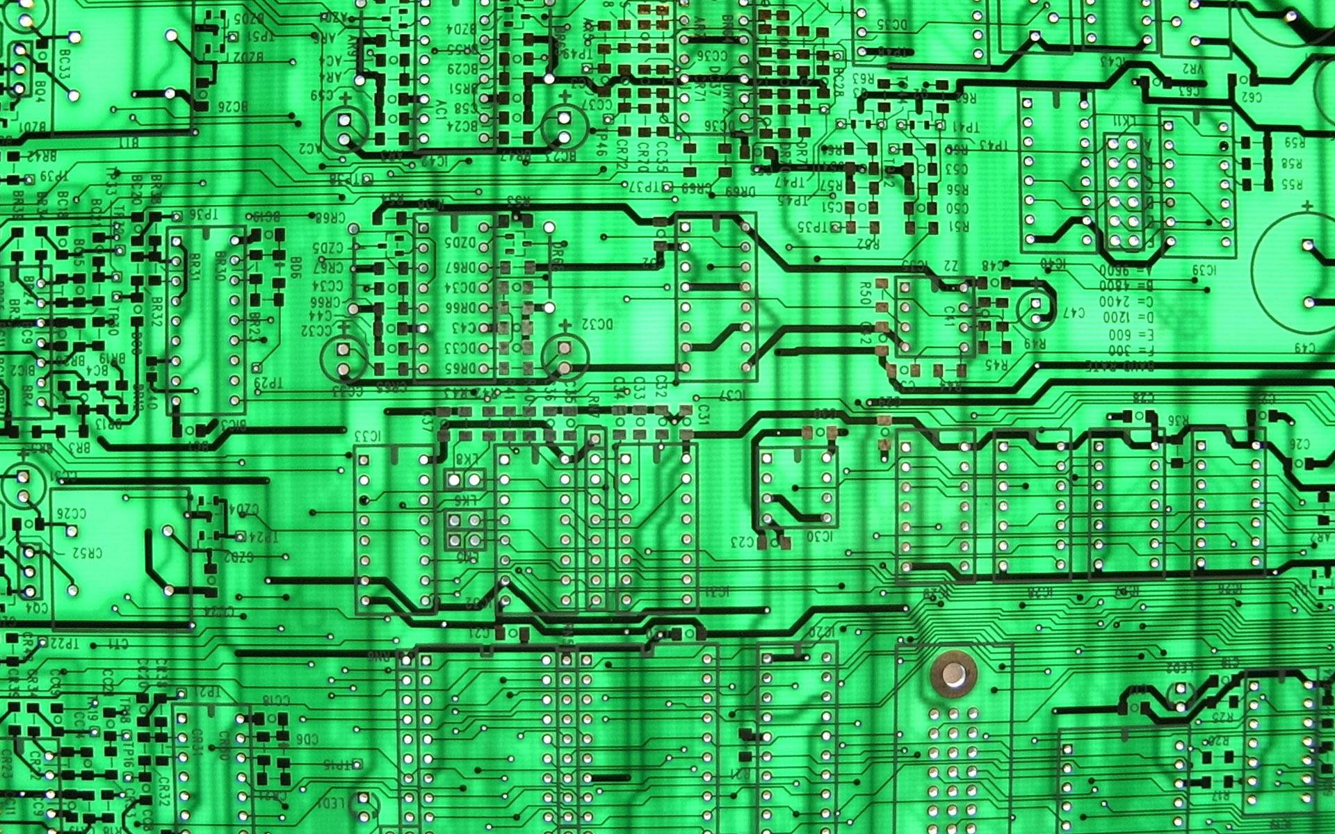 Circuit 桌布 壁紙 — 綠色電路板特寫，帶有複雜的黑色路徑和焊點，在柔和光線下。
