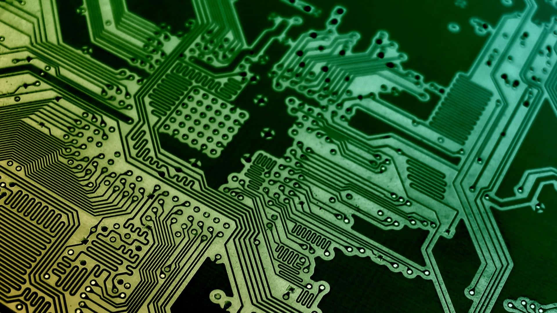 Circuit 桌布 壁紙 — 綠色電路板的特寫，具有複雜的金屬路徑和焊點，在戲劇性的燈光下。