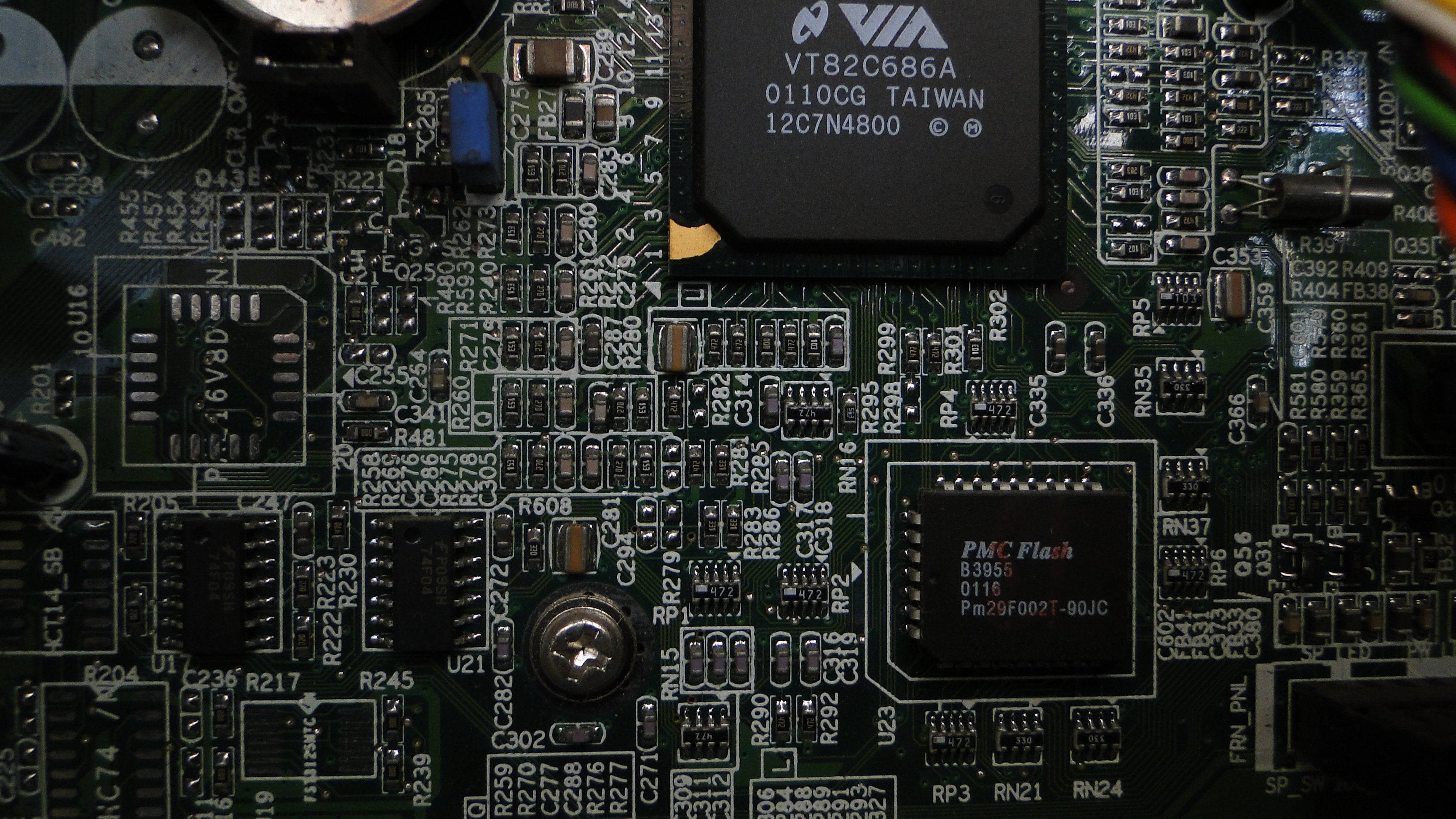 Circuit 桌布 壁紙 — 綠色電路板的特寫，帶有複雜的電子元件和可見的文字標籤，在溫暖的燈光下。