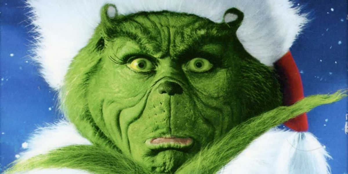 鬼靈精 桌布 壁紙 — 綠色鬼靈精戴著聖誕帽，在飄雪的藍色夜空下的特寫。