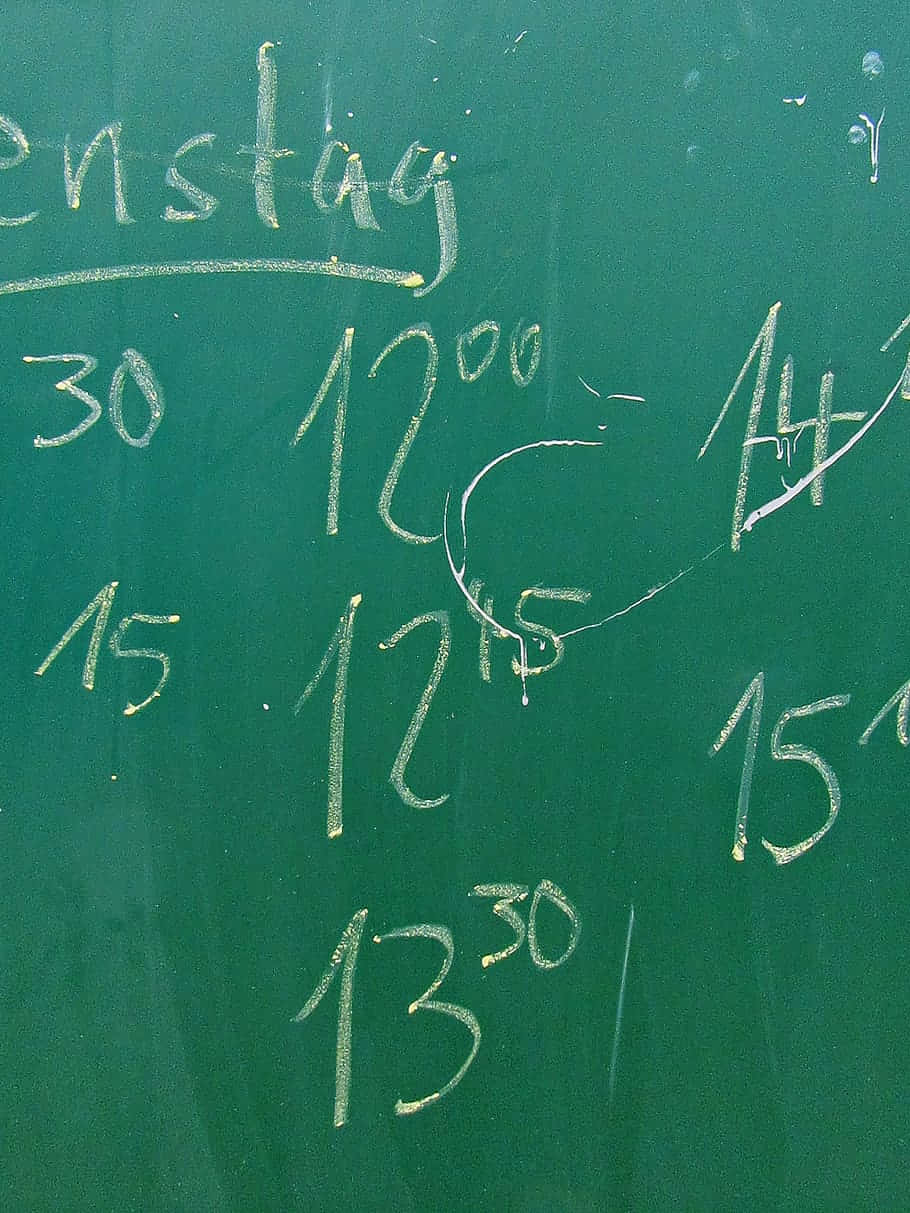 Green Chalkboard 桌布 壁紙 — 綠色黑板特寫，上面有白色粉筆手寫的德語課堂時間表，顯示時間和數字。