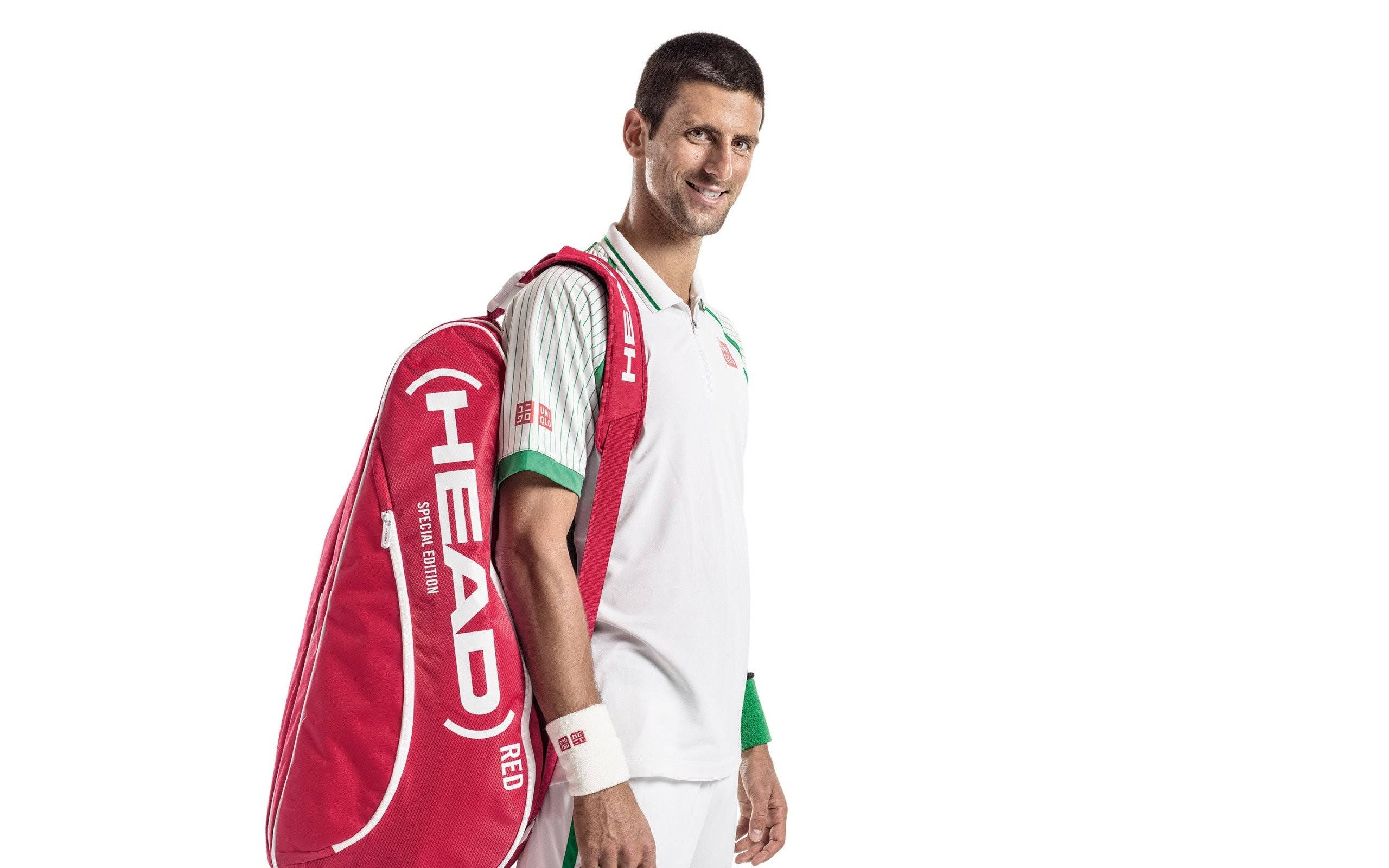 Novak 桌布 壁紙 — 網球冠軍諾瓦克·喬科維奇微笑著背著紅色Head網球袋，背景為純白色的寧靜肖像。