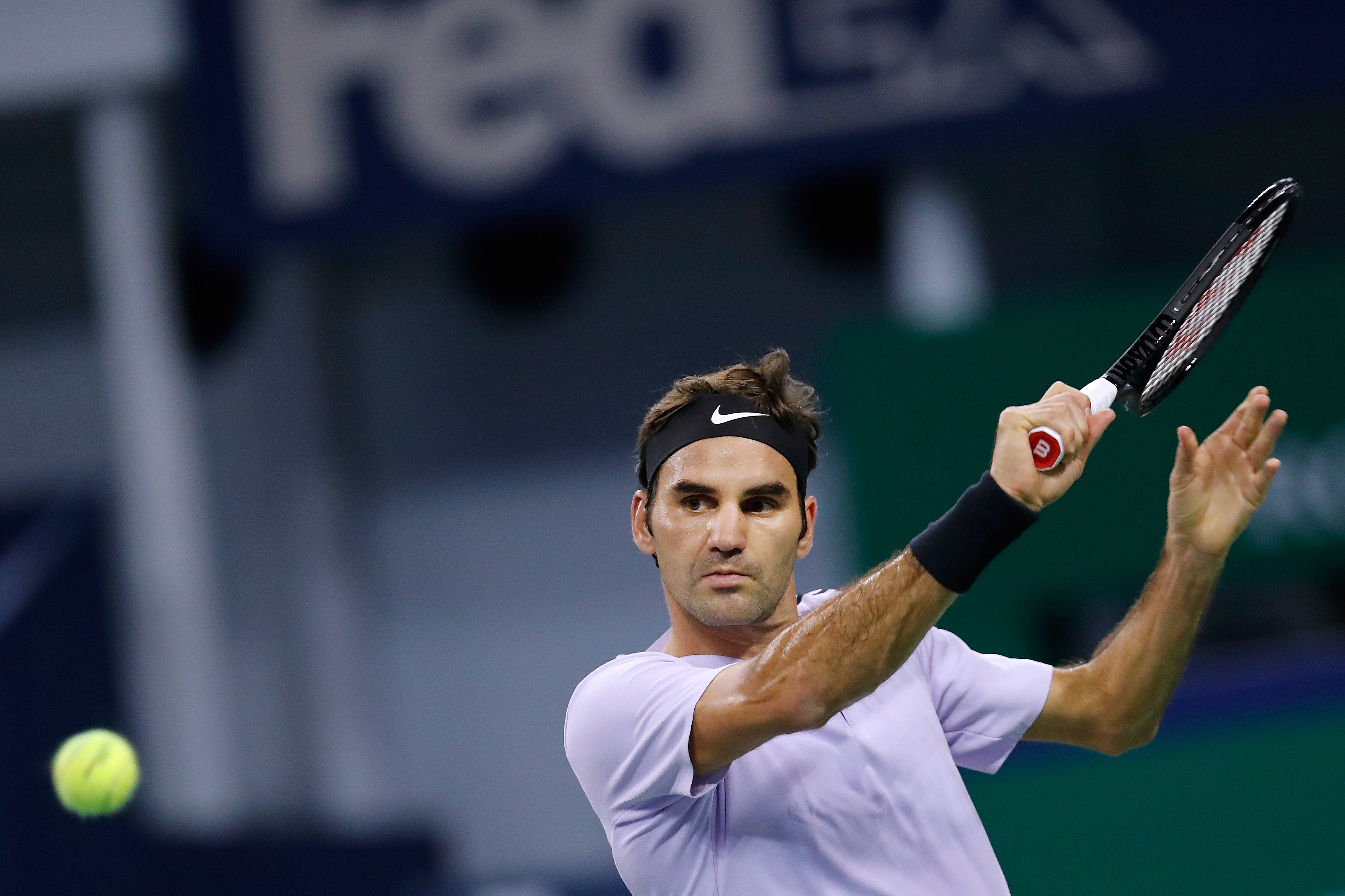 roger 桌布 壁紙 — 網球手羅傑·費德勒在夜間比賽中專注地揮拍擊打黃色球。